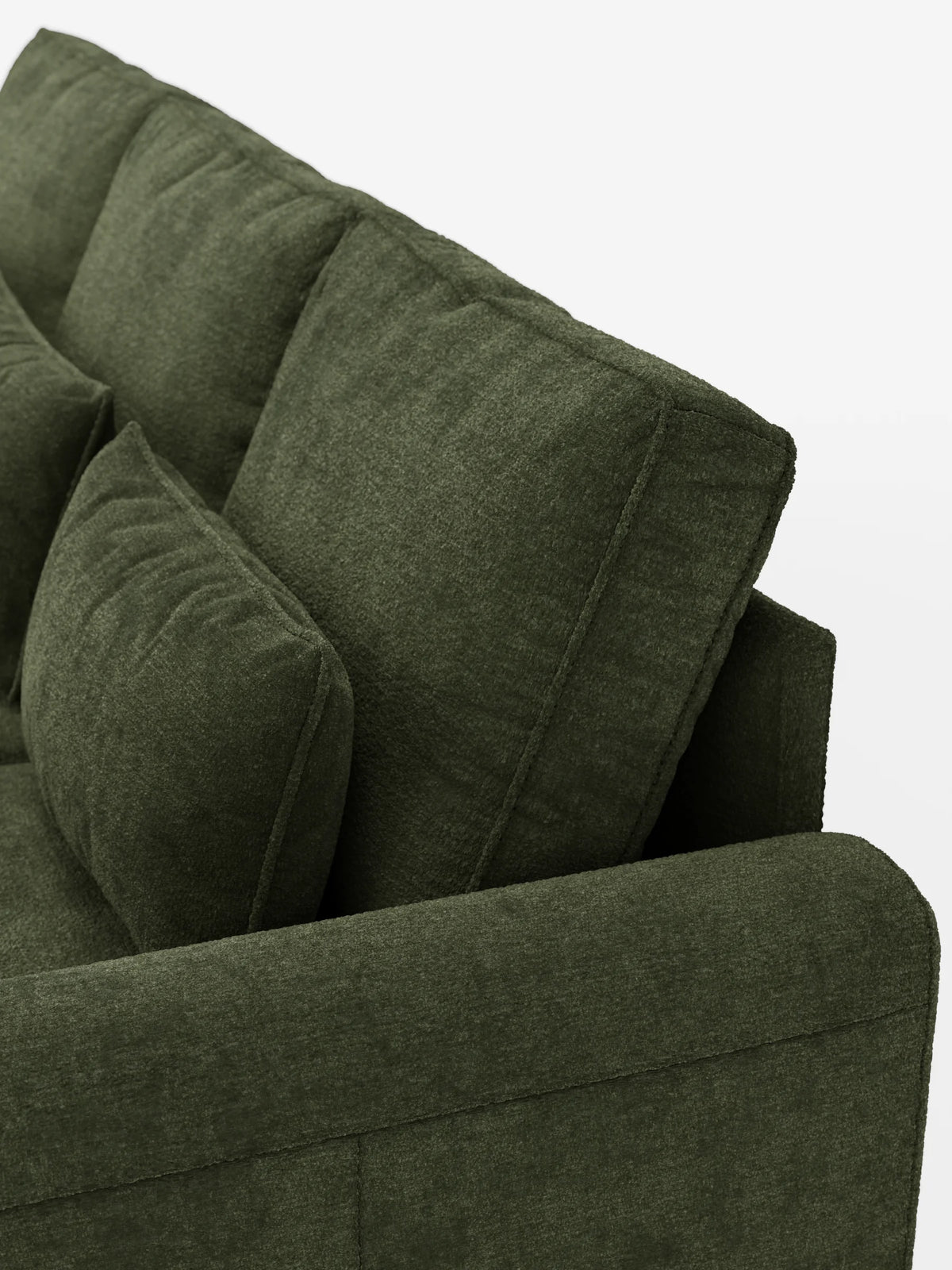 Un primo piano di un divano letto Ottaviano color verde oliva con letto estraibile – penisola reversibile e contenitore in tessuto materico smacchiabile –, che mette in risalto i cuscini dello schienale, un cuscino sfoderabile e un bracciolo dalla trama ruvida su uno sfondo bianco sporco.