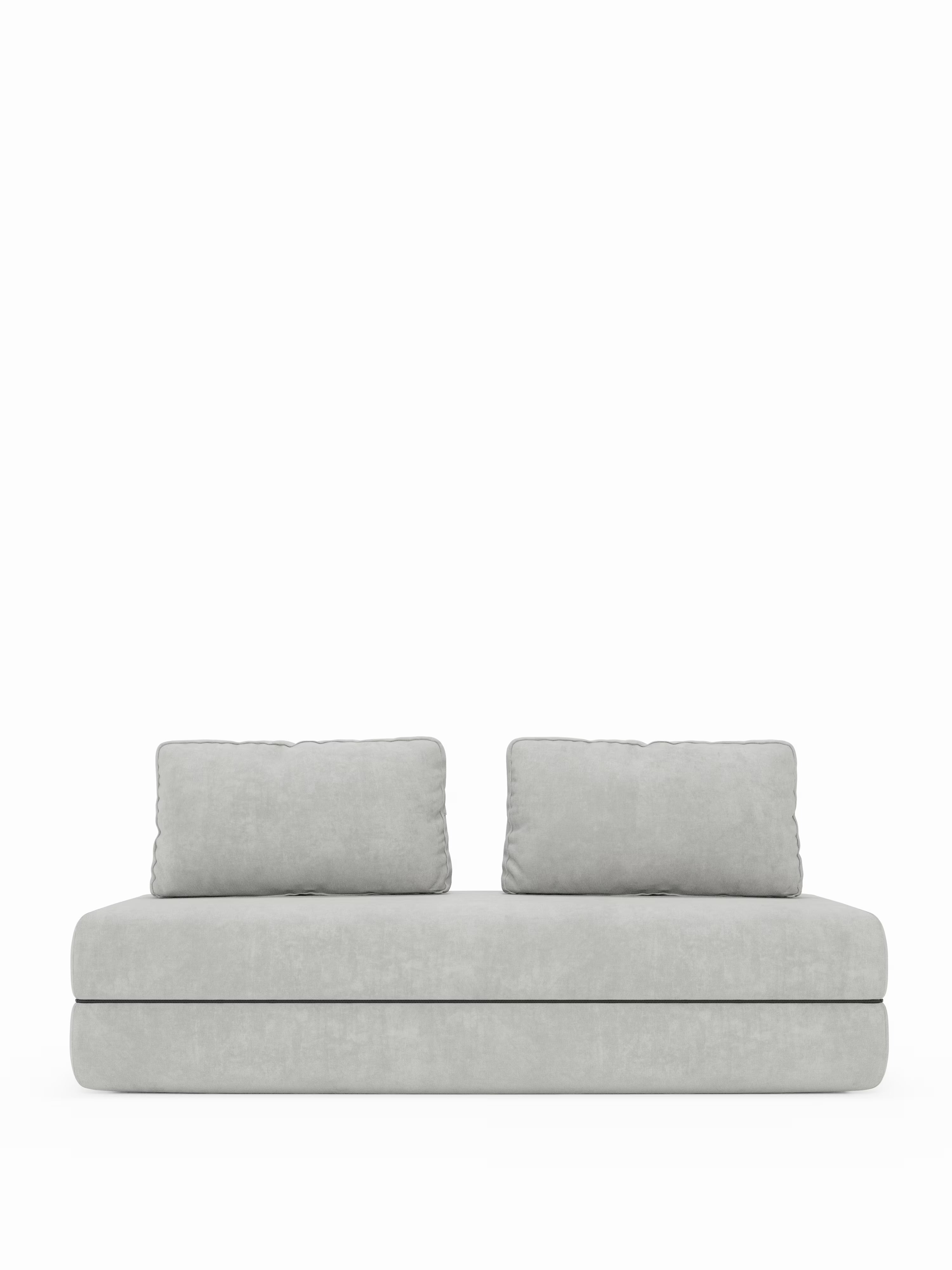 Un divano letto matrimoniale Rift in grigio chiaro dallo stile minimalista di Divani.Store, disponibile nella versione a 2 o 3 posti, è dotato di due ampi cuscini dello schienale rimovibili e di una spessa seduta rettangolare con un materasso in memory foam alto 22 cm nella versione T31. Il design moderno e semplice è caratterizzato da bordi morbidi e arrotondati, senza gambe o braccioli a vista, il tutto su uno sfondo bianco a tinta unita.
