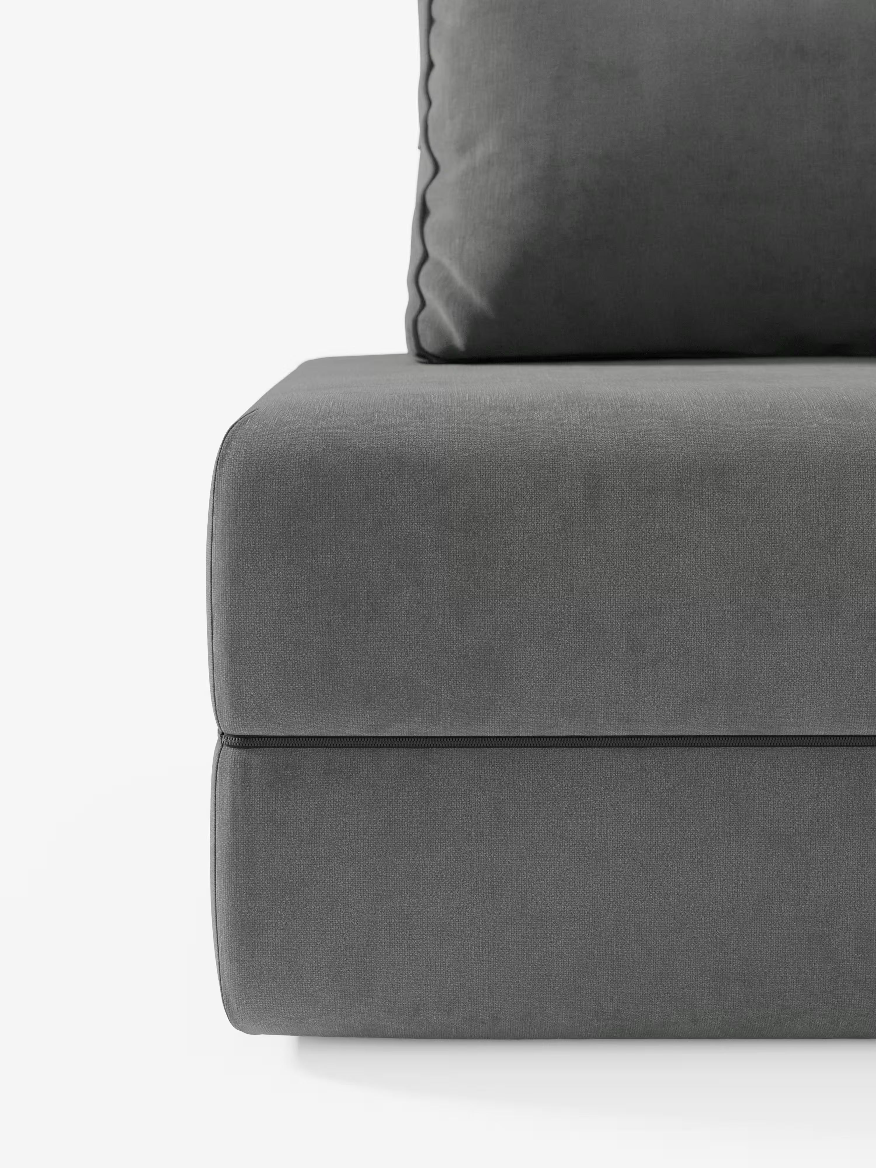 Primo piano della poltrona letto Rift di Divani.Store, rivestita in morbido tessuto T31 smacchiabile grigio scuro. L’immagine mette in risalto il design moderno caratterizzato dallo schienale mobile (regolabile), da un morbido cuscino di seduta e da un cuscino con bordo a zigzag. Lo sfondo bianco a tinta unita accentua le linee pulite e l’estetica minimalista di questo divano letto, dotato di un materasso in memory foam alto 24 cm per un comfort ancora maggiore.