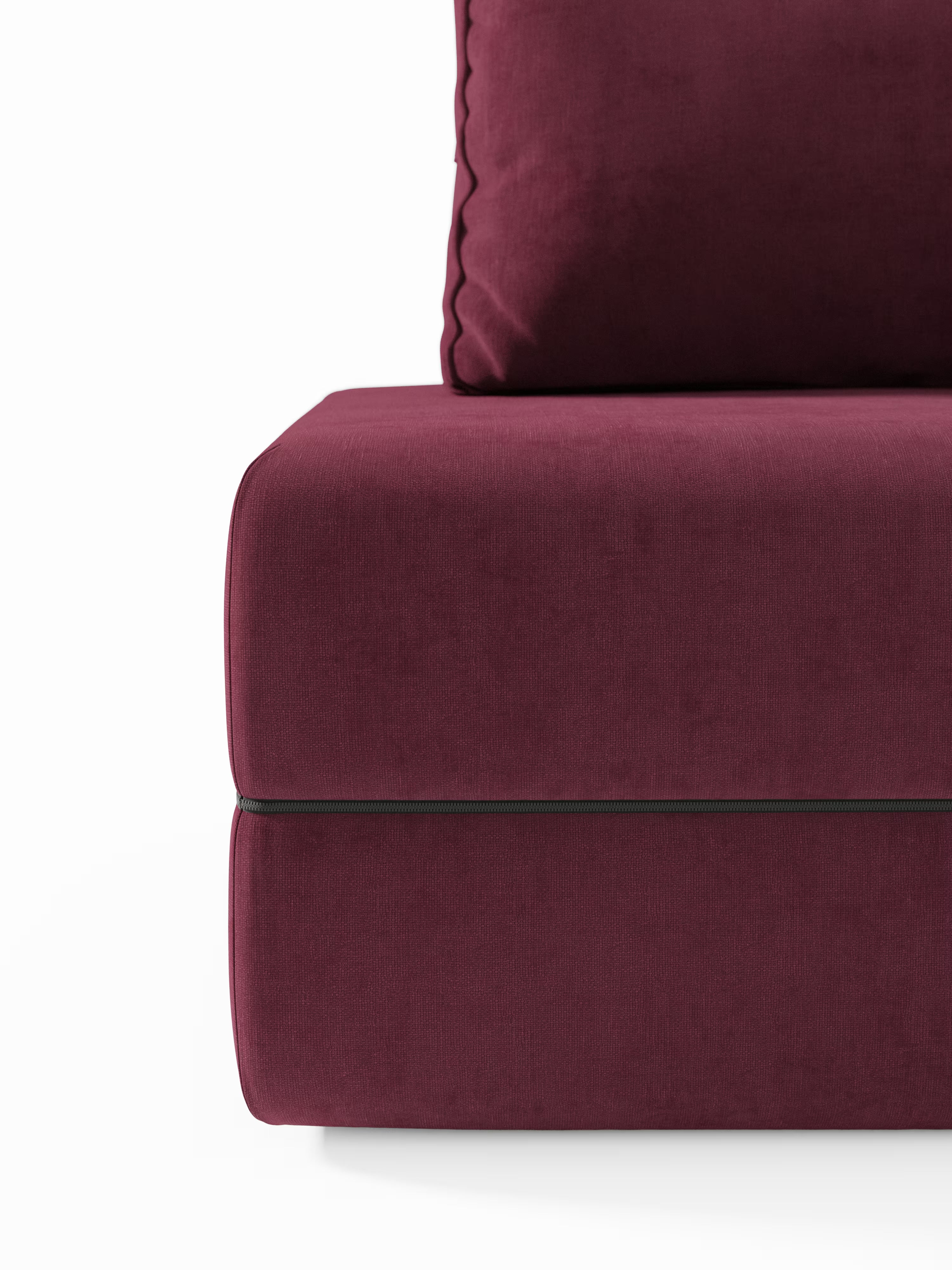 Primo piano della poltrona letto Rift con materasso alto 24 cm e memory foam di Divani.Store, rivestita in tessuto T31 color bordeaux intenso e resistente alle macchie. L'immagine mette in risalto una sezione dei cuscini della seduta e dello schienale, evidenziando lo schienale mobile e i bordi rifiniti con piping su uno sfondo bianco a tinta unita. Il rivestimento appare morbido, soffice e liscio, a testimonianza di un'elegante maestria artigianale moderna.
