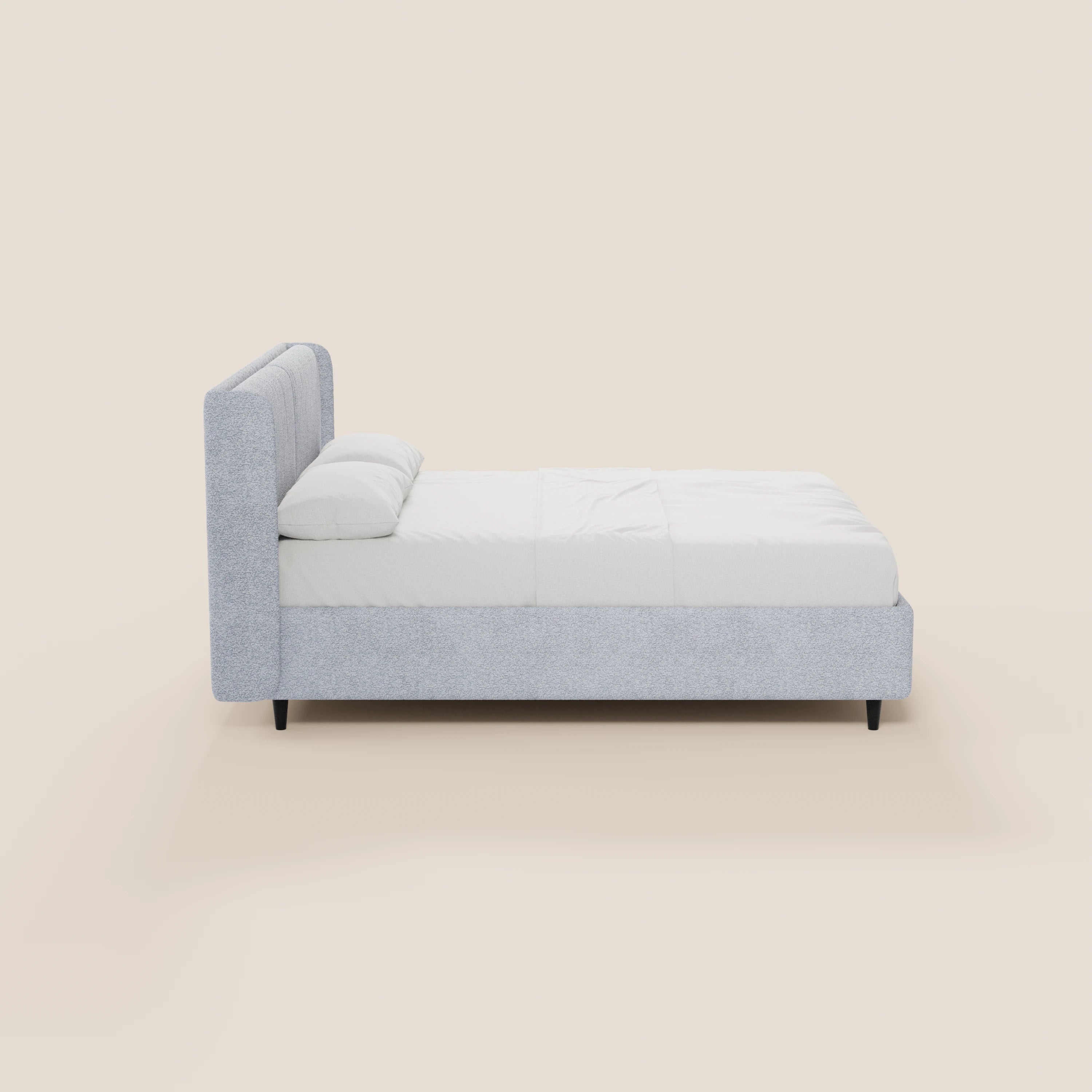 Il modello VALKIRIA di Letti.store è un letto di design minimalista con vano contenitore, testiera avvolgente, 2 cuscini imbottiti e rivestimento in tessuto Oeko-Tex®, qui presentato in grigio chiaro con gambe corte nere: ideale per un ambiente contemporaneo.
