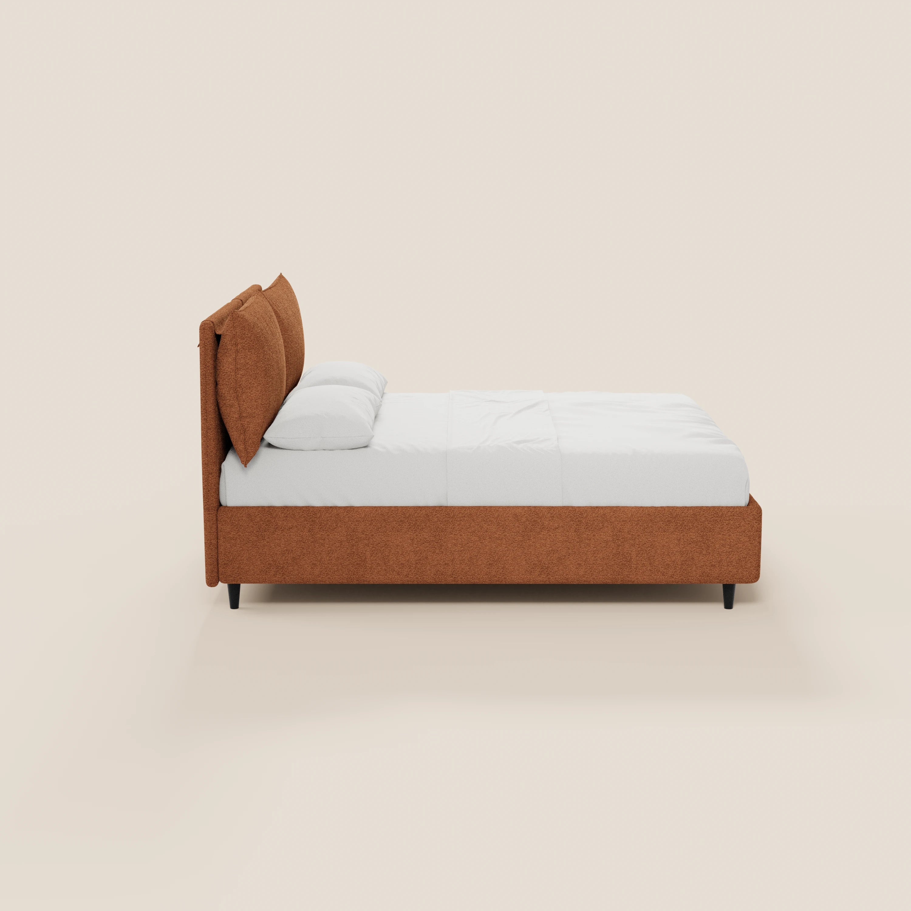 Vista laterale del letto imbottito ZAYRON di Letti.store, caratterizzato da una struttura in tessuto color ruggine certificato Oeko-Tex®, testiera imbottita regolabile, biancheria da letto bianca e gambe corte nere, su uno sfondo beige a tinta unita.