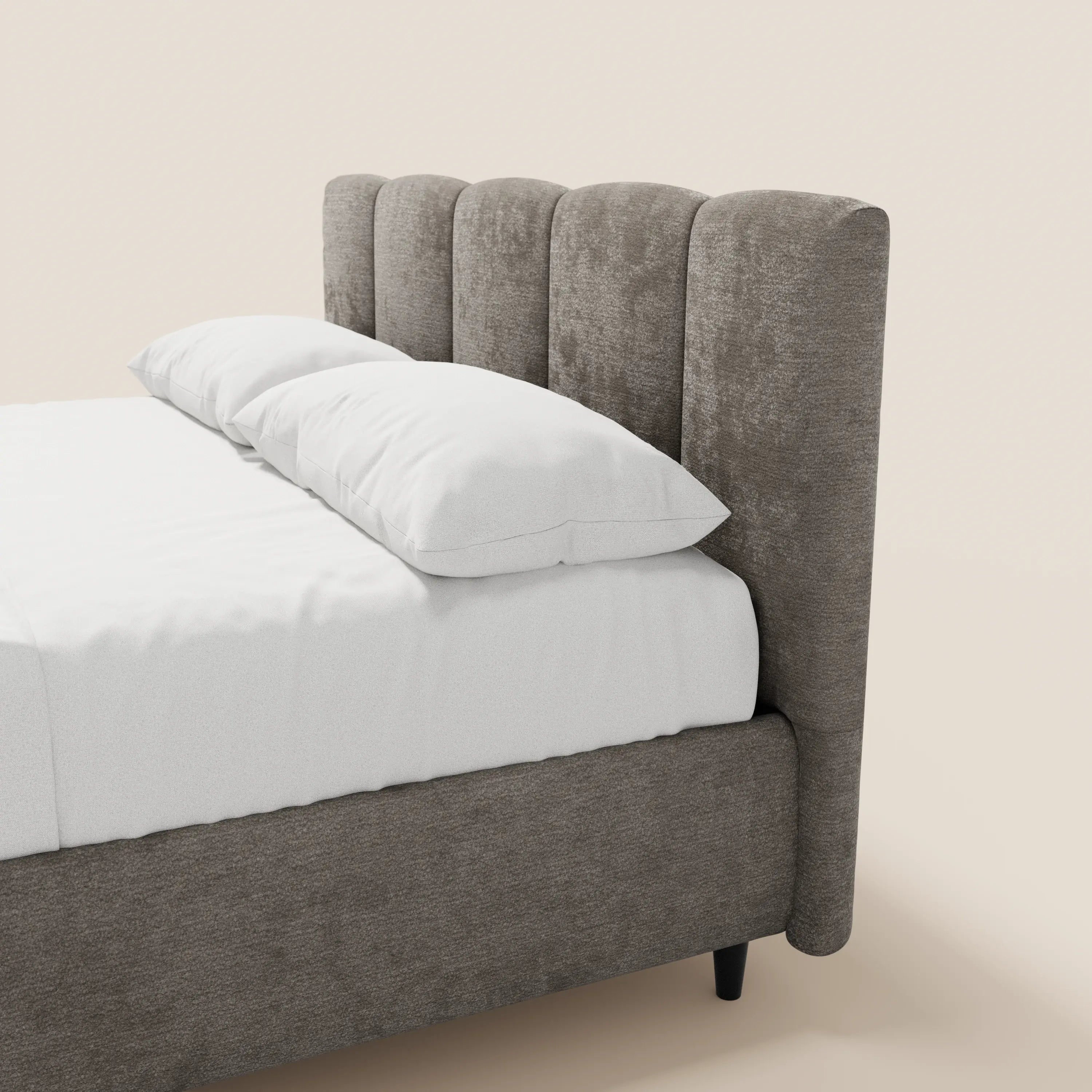 Il letto imbottito ARKAM di Letti.store è realizzato in tessuto Oeko-Tex® marrone chiaro con trama in rilievo e presenta una testiera alta con cuciture verticali; nella foto è raffigurato ben rifatto con lenzuola e cuscini bianchi su uno sfondo beige a tinta unita, con la vista laterale destra.