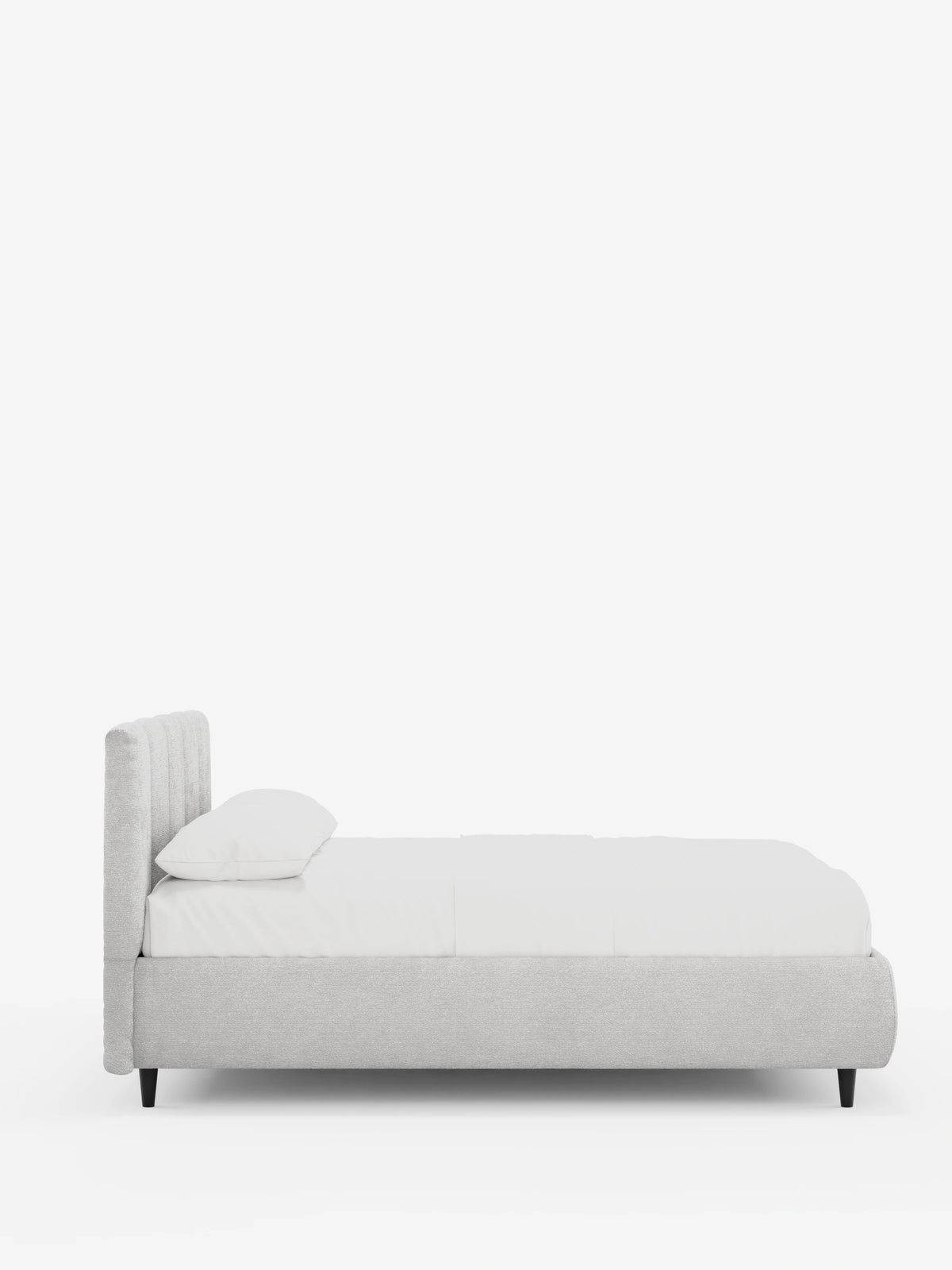 Vista laterale di un letto imbottito ARKAM con contenitore e testiera a pannelli verticali in grigio chiaro, caratterizzato da una testiera alta con pannelli verticali, lenzuola bianche immacolate e piccole gambe nere su sfondo bianco.