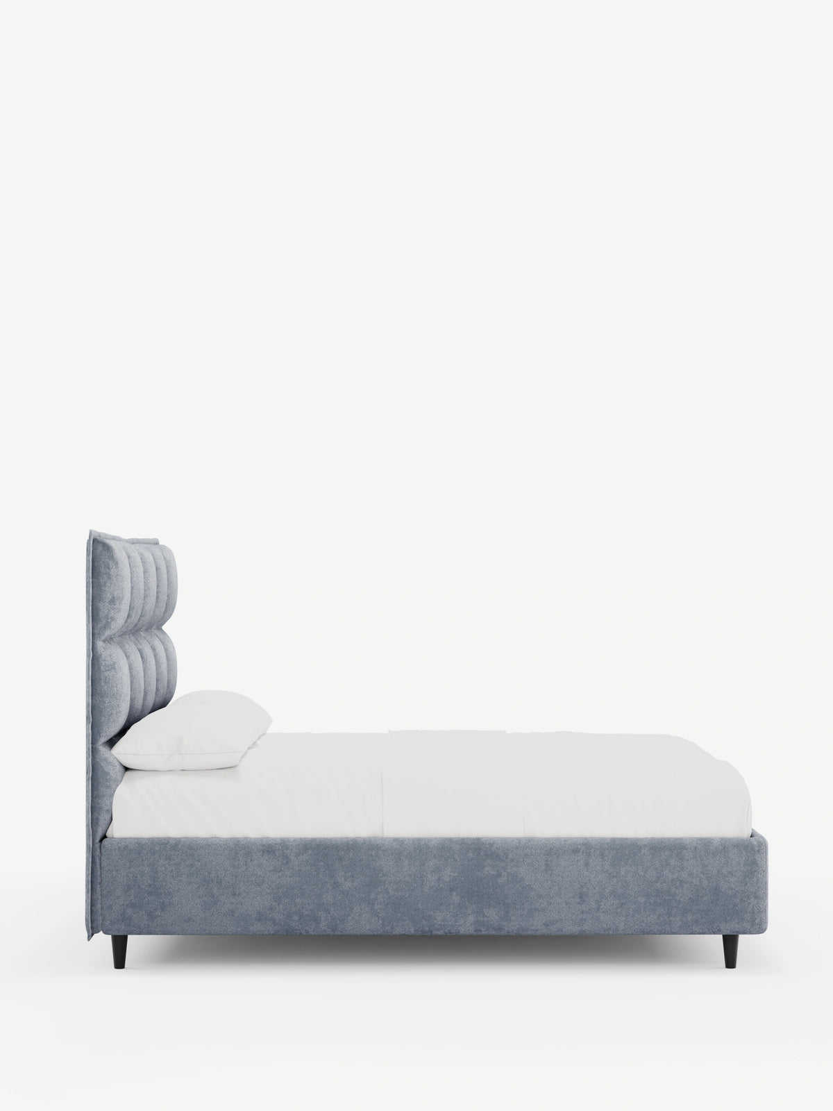 Vista laterale di un letto imbottito AURO con contenitore e testiera alta capitonné in ciniglia Oeko-Tex® di colore grigio, con biancheria da letto bianca e una struttura imbottita e spessa su uno sfondo bianco a tinta unita.