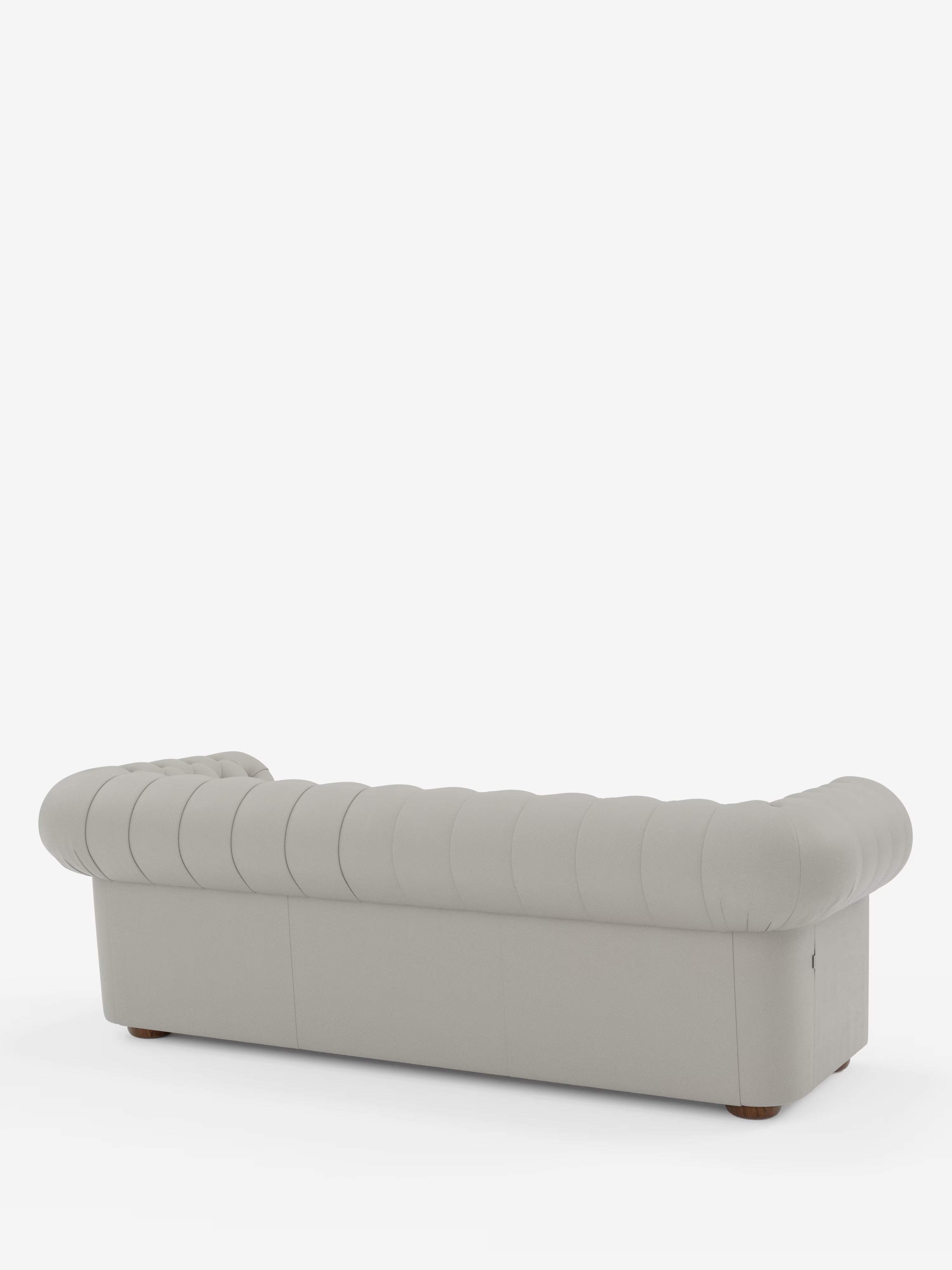 Il divano Chester 4 Posti 3 sedute in vera pelle – Chesterfield capitonné artigianale di Divani.Store è ripreso di retro su uno sfondo bianco a tinta unita. Questo divano grigio chiaro presenta dettagli capitonné sullo schienale, braccioli arrotondati e gambe in legno dal profilo basso. Realizzato con maestria in Italia con rivestimento in vera pelle liscia, unisce l’eleganza moderna allo stile classico Chesterfield.