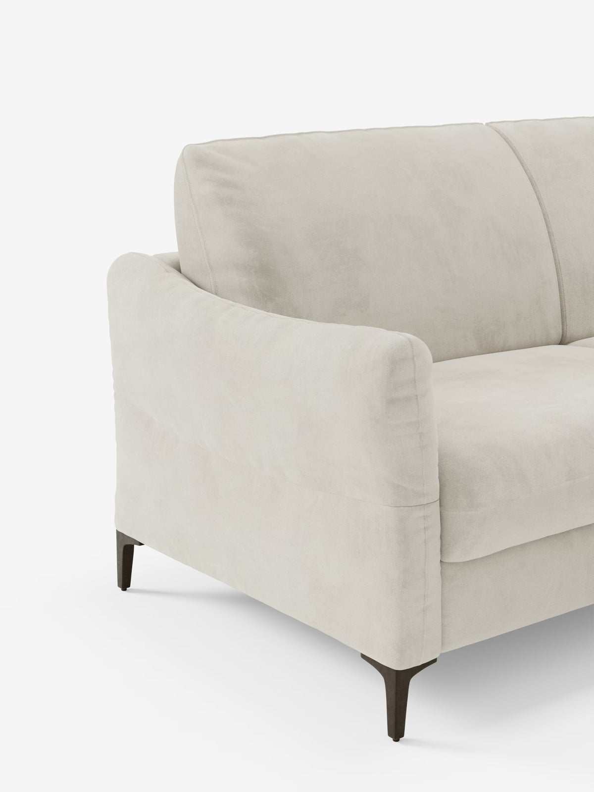 Un moderno divano letto Dalia di Divani.Store, qui raffigurato con rivestimento in velluto T30 beige chiaro, resistente alle macchie, con imbottitura morbida e sottili gambe in metallo scuro. Sono visibili solo il bracciolo sinistro e parte dello schienale e della seduta. Lo sfondo bianco a tinta unita mette in risalto le linee pulite e la morbida trama di questo divano letto a 2, 3 o 4 posti con materasso H18.