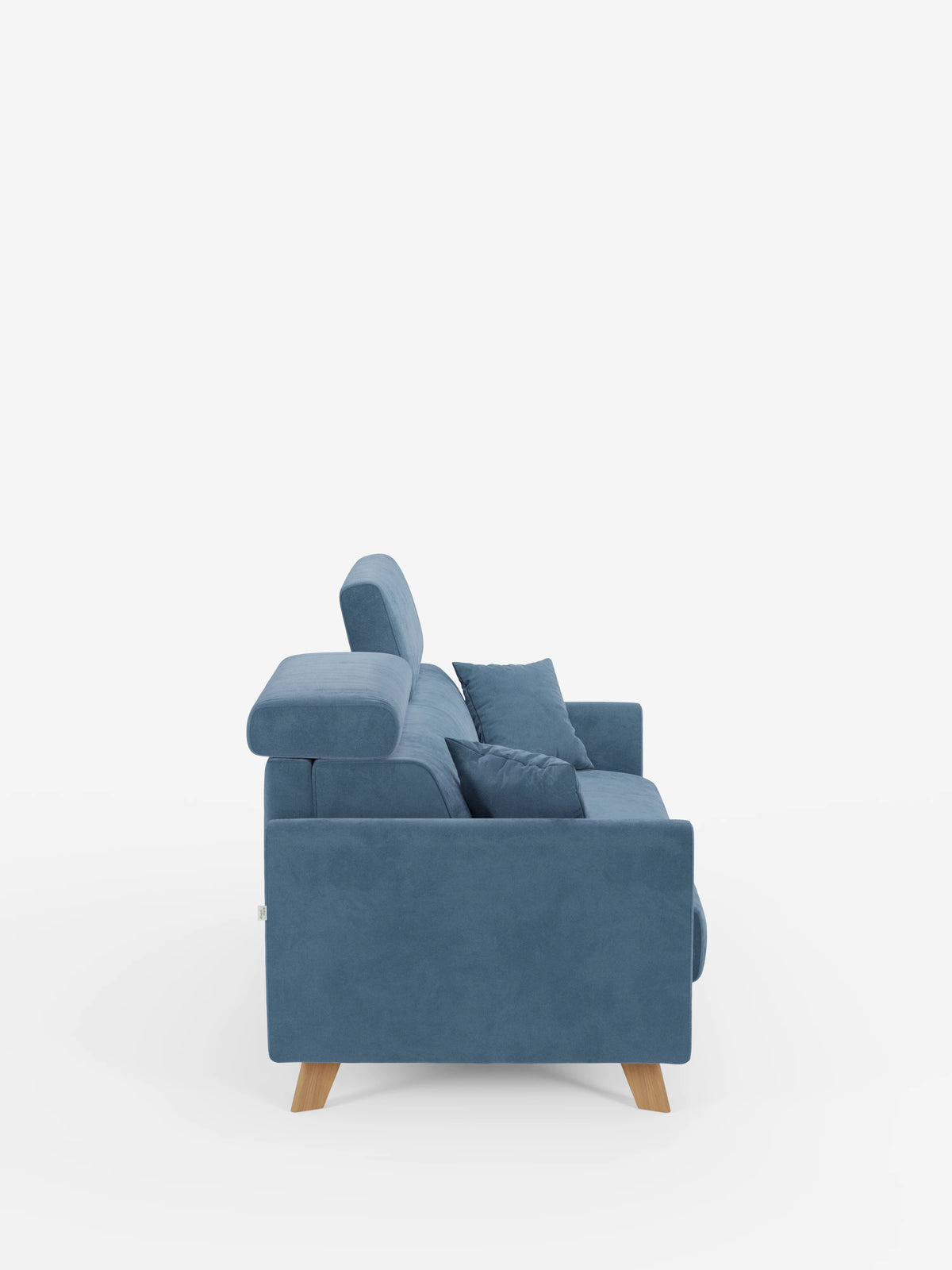 Vista laterale del divano letto Francy con poggiatesta regolabili di Divani.Store, un moderno divano a tre posti realizzato in elegante tessuto blu T30 resistente alle macchie, caratterizzato da gambe in legno, poggiatesta regolabili e due cuscini coordinati. Il rivestimento, sfoderabile al 100%, e il design slanciato dalle linee dritte e pulite risaltano sullo sfondo bianco a tinta unita.