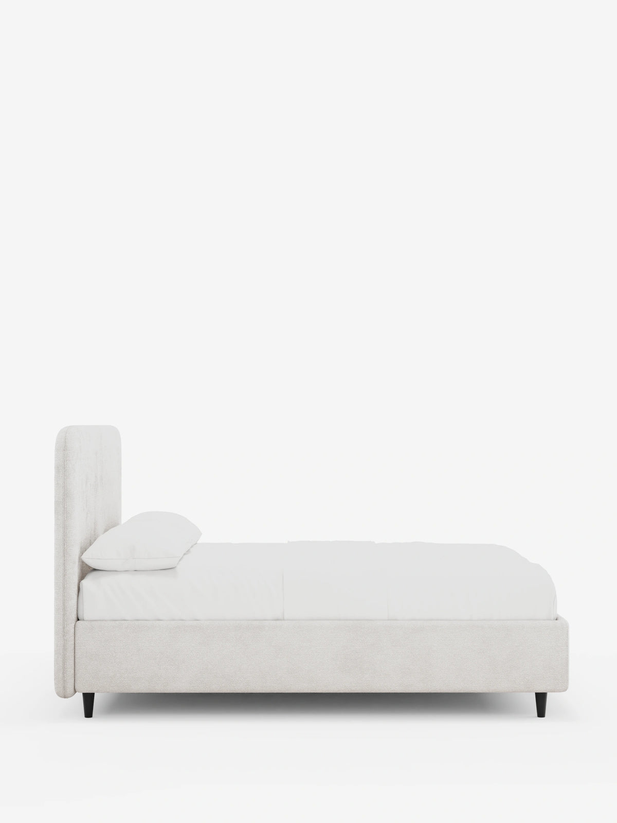 Vista laterale di un letto imbottito KAELOS Letto Minimal, caratterizzato da una testiera arrotondata e da un tessuto testurizzato di colore chiaro. Il letto poggia su sottili gambe nere su uno sfondo bianco ed è rivestito con biancheria da letto bianca e un unico cuscino.