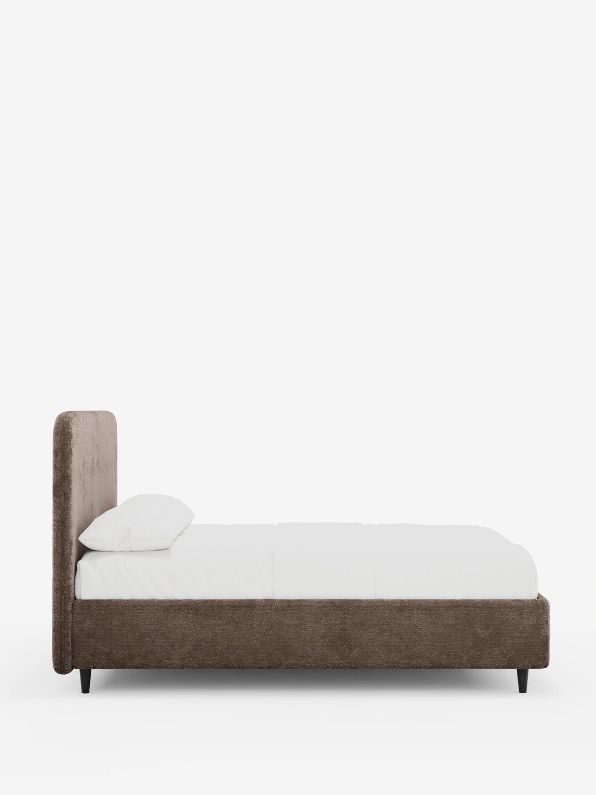 Vista laterale di un letto KAELOS minimal imbottito con struttura in tessuto chenille marrone a trama ruvida, testiera alta e arrotondata, biancheria da letto bianca e sottili gambe nere su uno sfondo chiaro e uniforme.