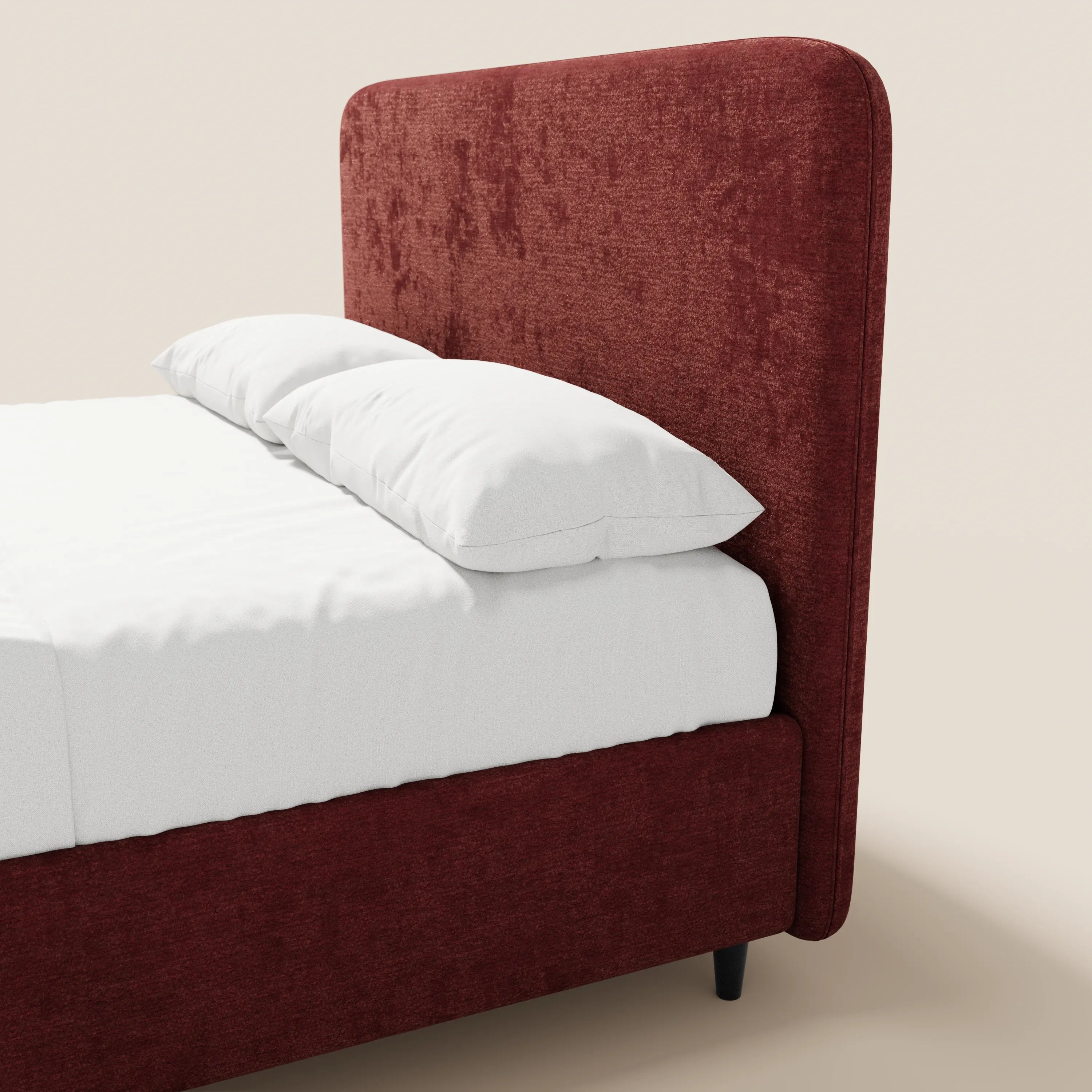 Il letto imbottito KAELOS minimal di Letti.store presenta una testiera alta e arrotondata in ciniglia e una struttura di colore rosso intenso, con piedini alti e vano contenitore. Nell’immagine è raffigurato in parte con lenzuola e cuscini di un bianco candido, su uno sfondo beige chiaro.
