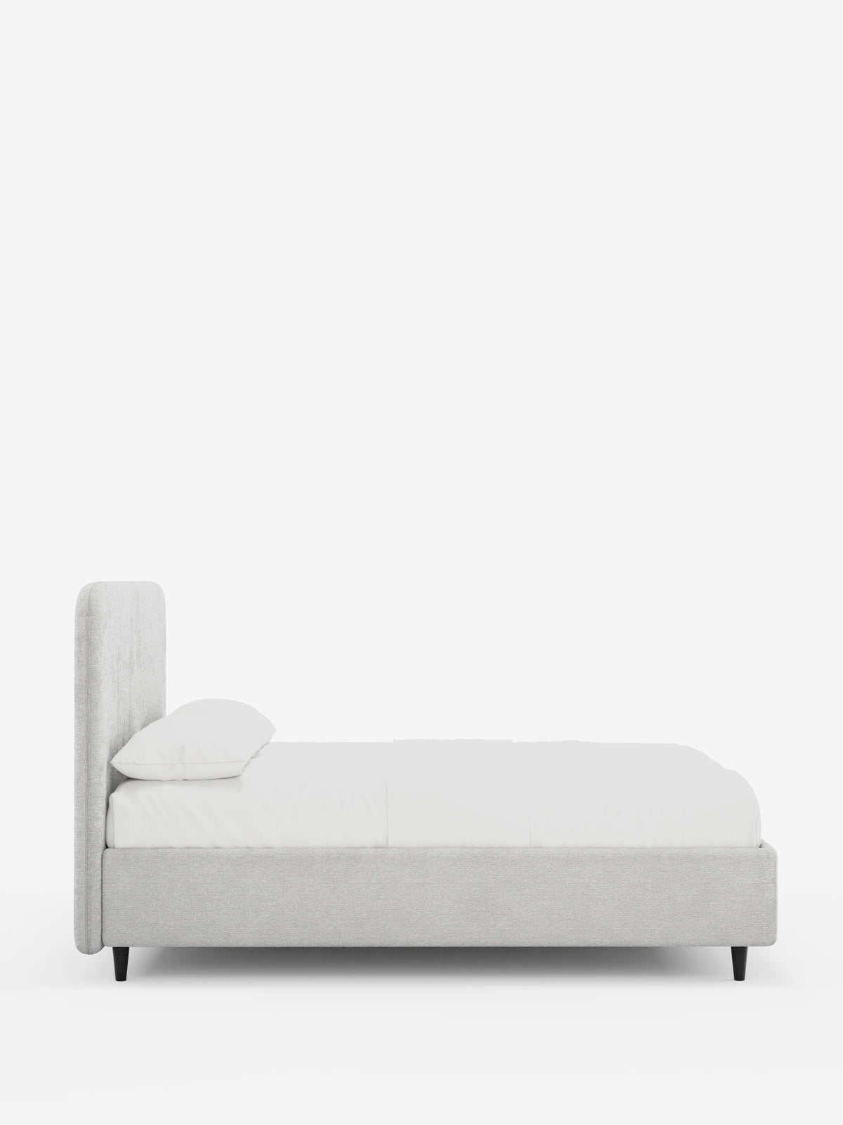 Vista laterale di un letto KAELOS minimal imbottito color grigio chiaro - con contenitore, gambe alte e testiera arrotondata in tessuto ciniglia, con una testiera arrotondata e gambe alte e sottili di colore nero, rivestito con biancheria da letto bianca su uno sfondo bianco sporco.