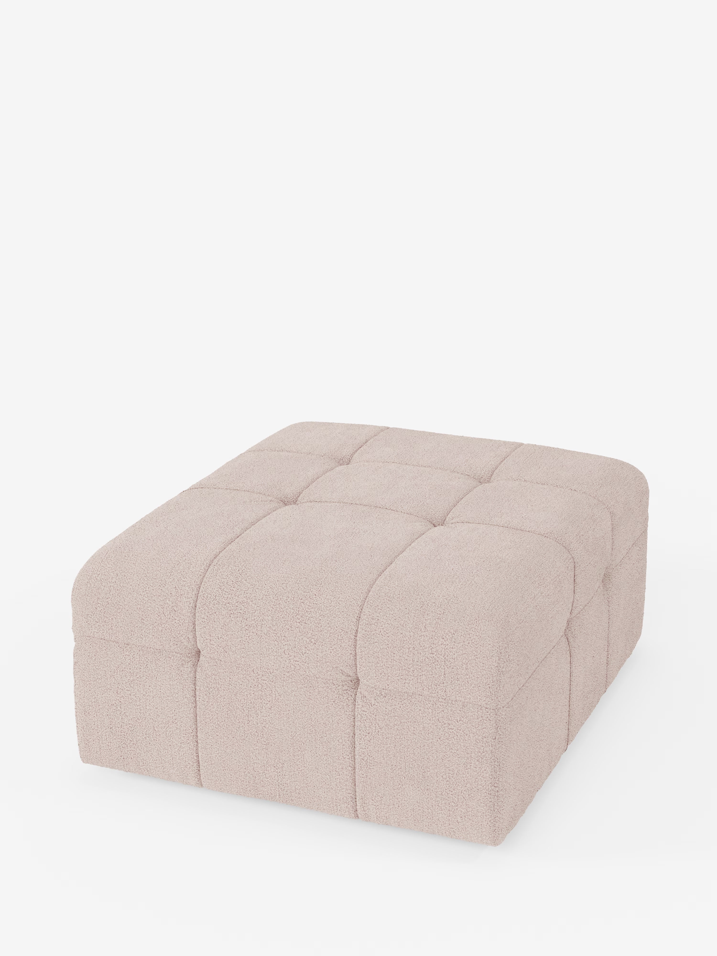 Un grande pouf quadrato di Divani.Store, il “Mosaic pouf e modulo in bouclé” (96x77 cm), presenta un design capitonné in tessuto T21 resistente alle macchie. Rivestito in morbido bouclé beige chiaro, la sua superficie soffice è disposta in una griglia di quadrati cuciti che creano un effetto imbottito e trapuntato che richiama la classica artigianalità italiana. Il pouf poggia direttamente su una base bianca senza gambe o piedini visibili.