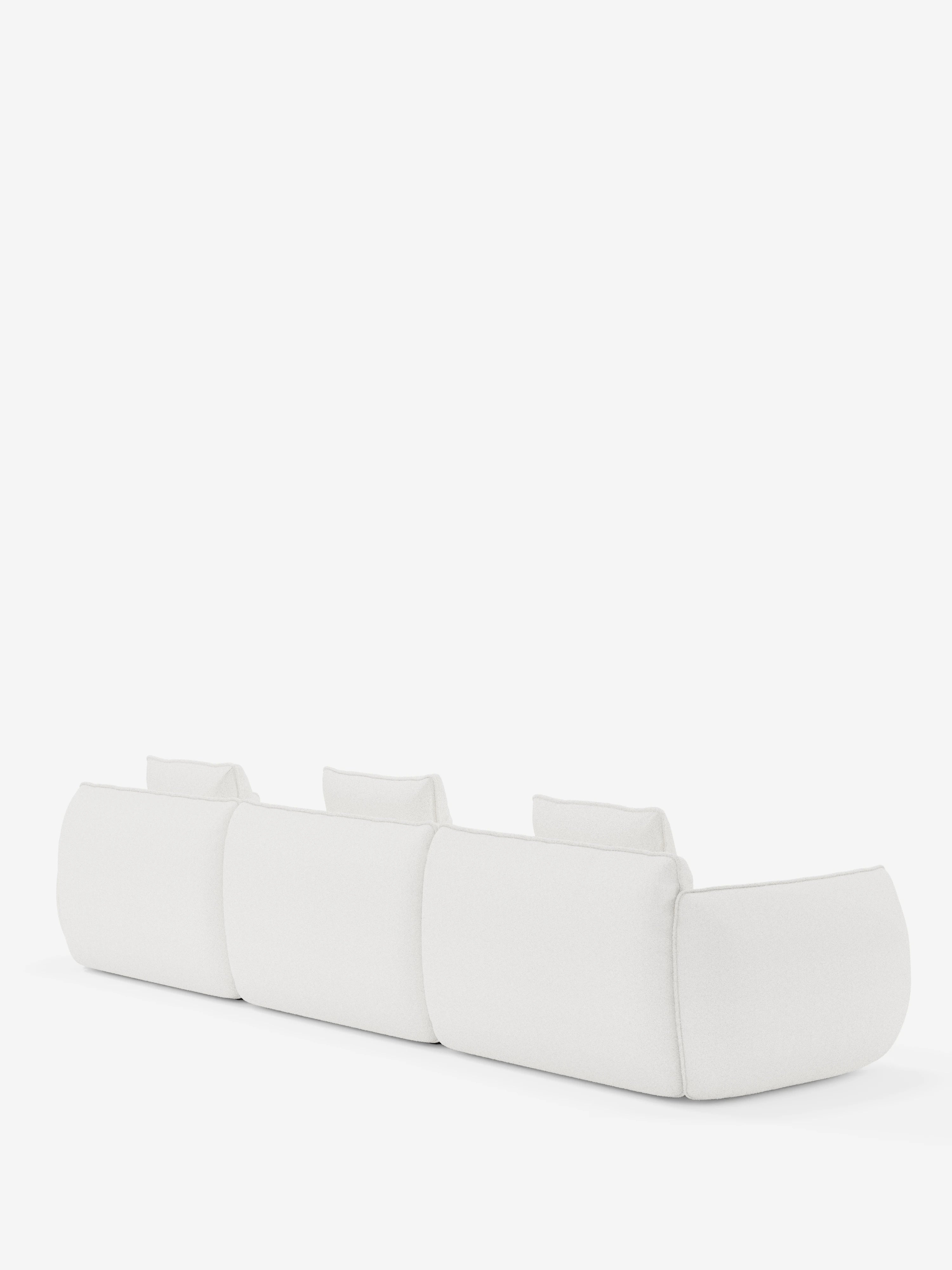 Un divano modulare Nimbus a tre posti, dal design contemporaneo e minimalista, firmato Divani.Store, caratterizzato da bordi leggermente arrotondati e schienali bassi, rivestito in tessuto T33 bianco effetto cotone, resistente alle macchie. Il divano è raffigurato di retro su uno sfondo bianco a tinta unita.