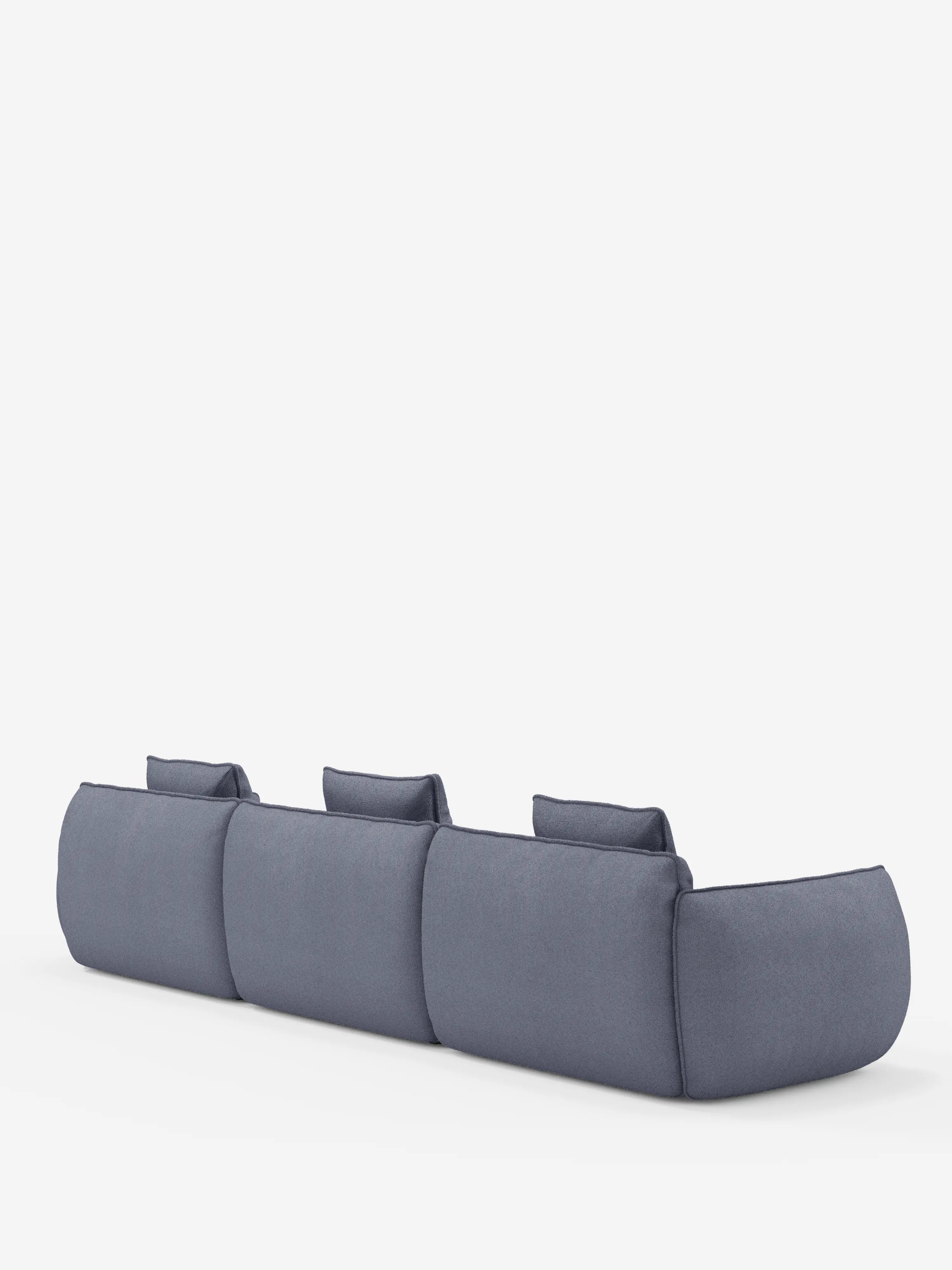 Il divano modulare a 3 posti Nimbus di Divani.Store, rivestito in morbido tessuto T33 effetto cotone, resistente alle macchie, in una tonalità di blu tenue, è ripreso di profilo dal retro. Caratterizzato da bordi delicati e arrotondati, braccioli bassi e tre cuscini rettangolari per lo schienale, il divano risalta su uno sfondo bianco a tinta unita.