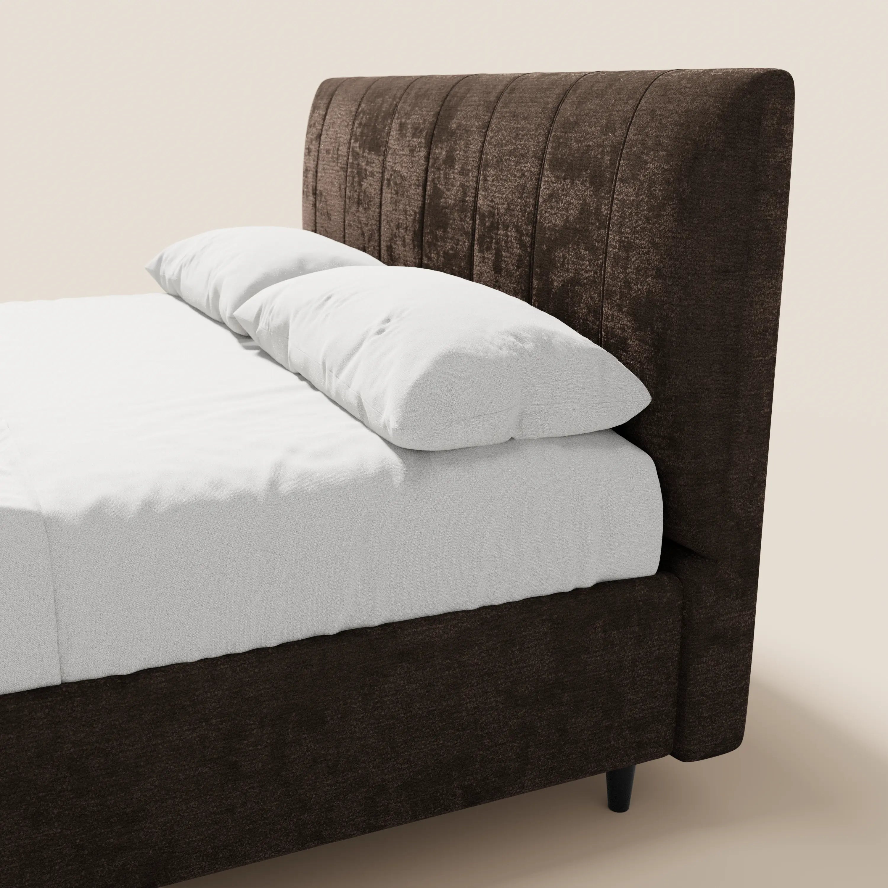 Un primo piano del letto imbottito con contenitore ONYX di Letti.store, caratterizzato da un’alta testiera verticale in tessuto certificato Oeko-Tex®, con cuciture verticali, rivestito con lenzuola bianche immacolate e due cuscini bianchi su uno sfondo beige chiaro.
