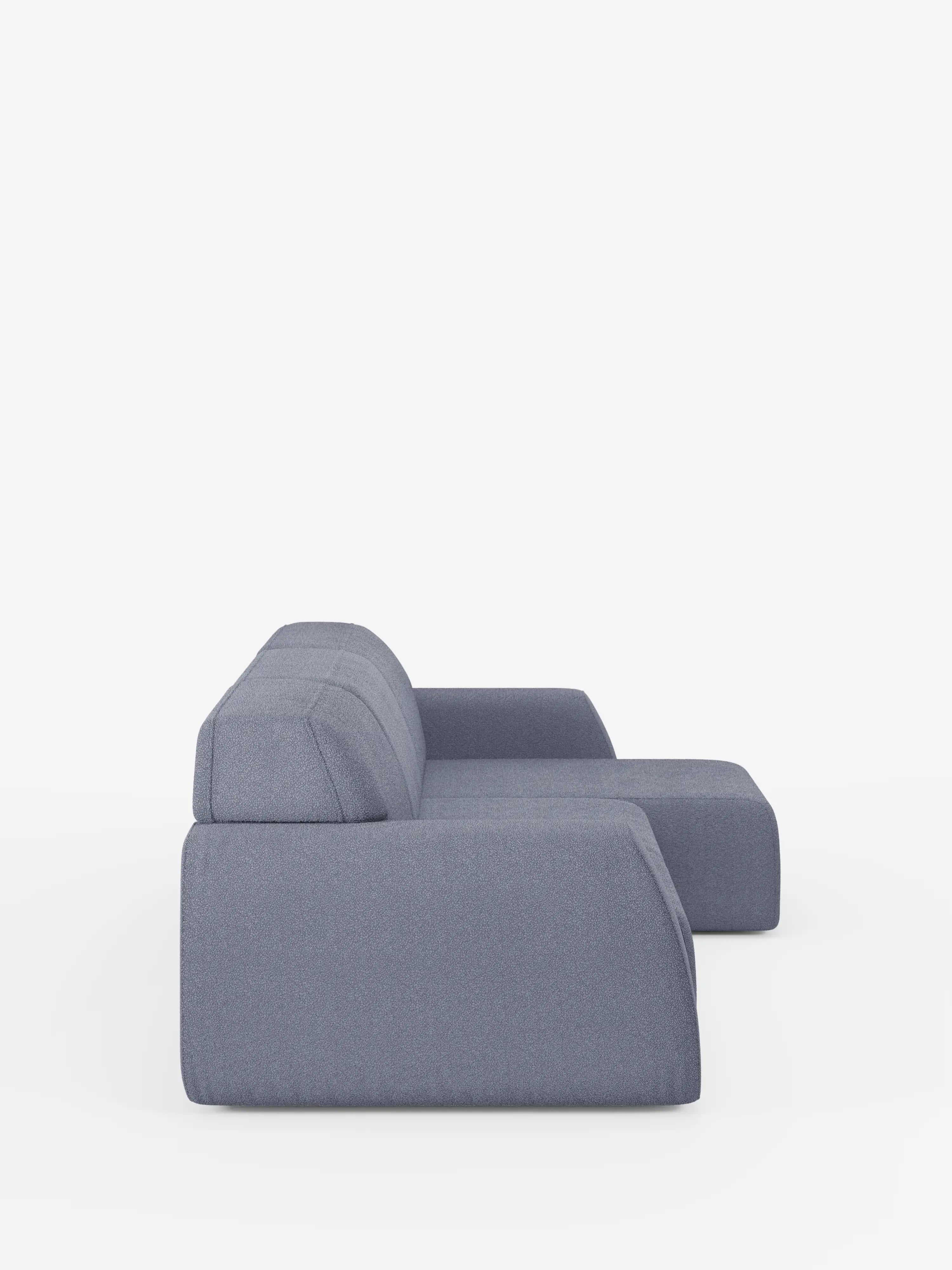 Vista laterale del divano angolare Orbit con penisola reversibile e tutte le sedute allungabili in tessuto smacchiabile effetto cotone T33 di Divani.Store, un moderno divano modulare imbottito grigio che si distingue per le linee pulite e i cuscini bassi e ampi, su uno sfondo bianco senza cuciture. Questo divano modulare di alta gamma presenta un design geometrico minimalista con una chaise longue reversibile annessa sulla destra, simbolo di qualità eccezionale.