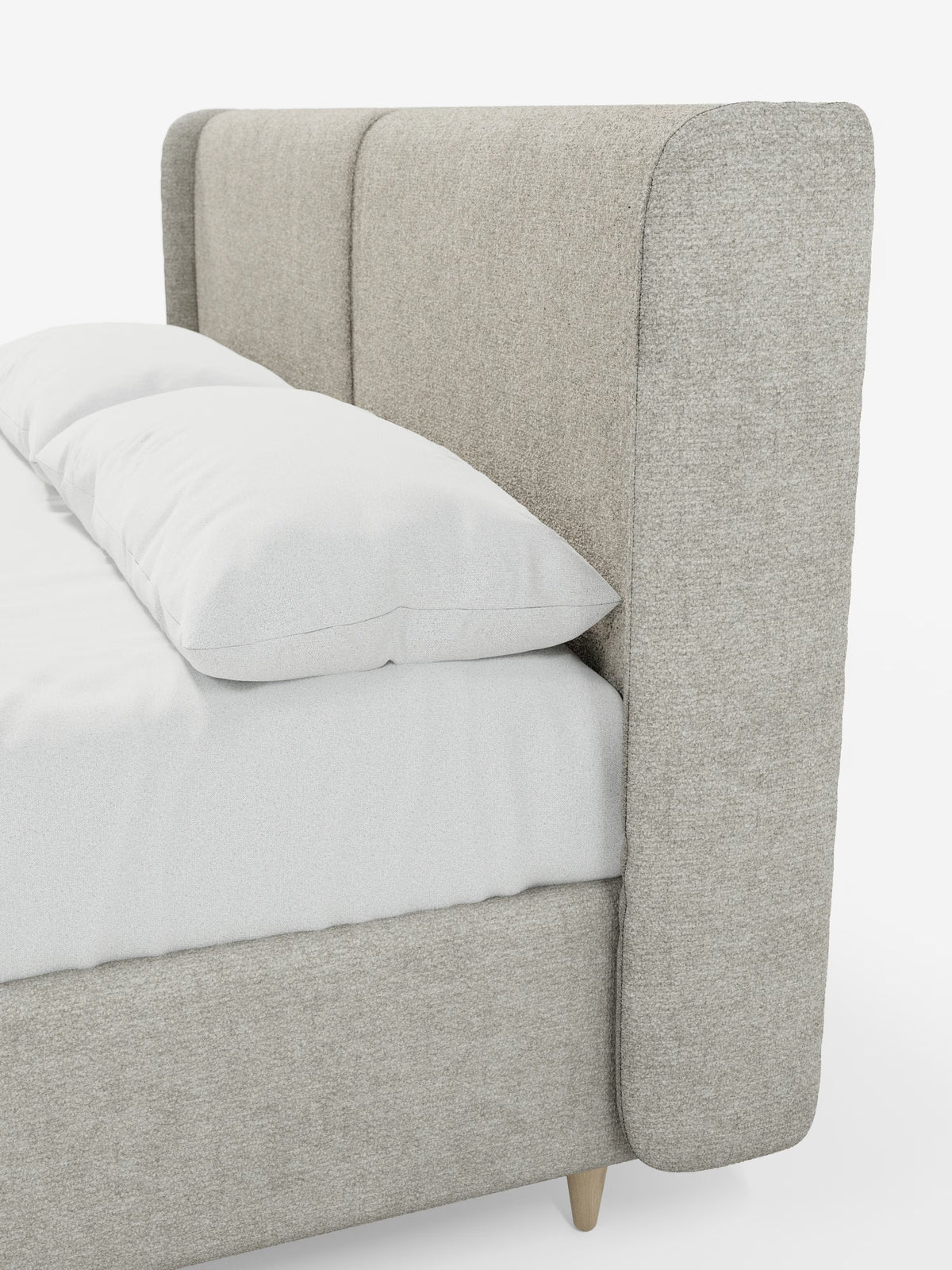 Un primo piano del letto imbottito bicolore VALKIRIA con contenitore di Letti.store, caratterizzato da una testiera alta in tessuto beige chiaro con pannelli verticali e angoli leggermente arrotondati. Il letto è abbellito da un lenzuolo con angoli bianco e da un cuscino bianco, mentre la struttura poggia su gambe in legno chiaro.