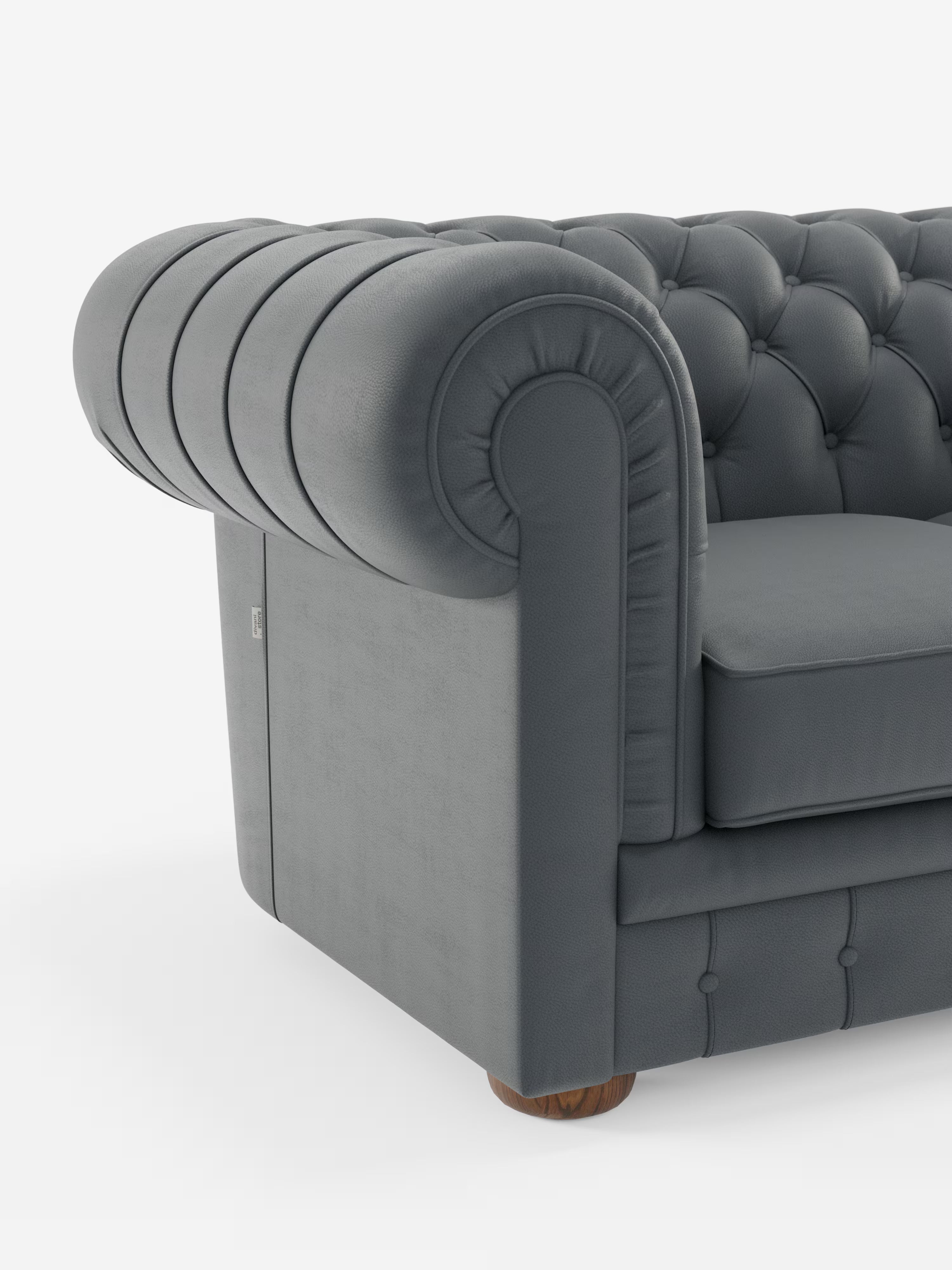 Un primo piano del bracciolo del divano Chester 4 Posti 3 sedute in Vera Pelle – Chesterfield Capitonné Artigianale di Divani.Store ne mette in risalto la linea elegantemente arrotondata e l’imbottitura generosa, impreziosita dalla classica trapuntatura a bottoni sia sullo schienale che sul bracciolo. Rivestita in lussuosa vera pelle, la base emana raffinatezza, mentre una gamba rotonda in legno è parzialmente visibile sotto questo squisito divano Made in Italy.