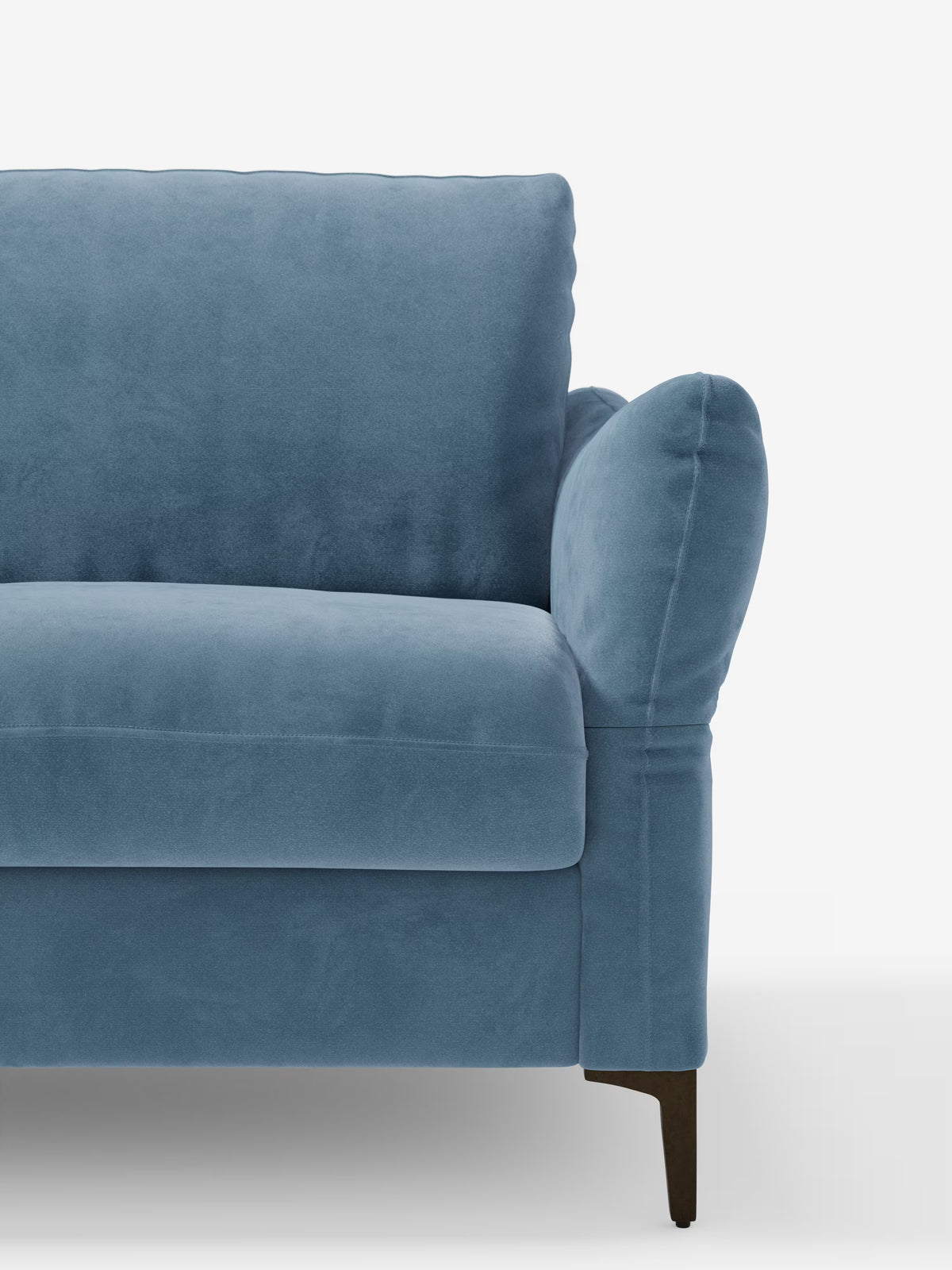 Un primo piano del divano letto Dalia di Divani.Store, rivestito in moderno velluto T30 blu resistente alle macchie, che mostra il lato sinistro con seduta morbida, cuscino dello schienale e bracciolo imbottito, il tutto poggiato su gambe affusolate in legno scuro su uno sfondo bianco.