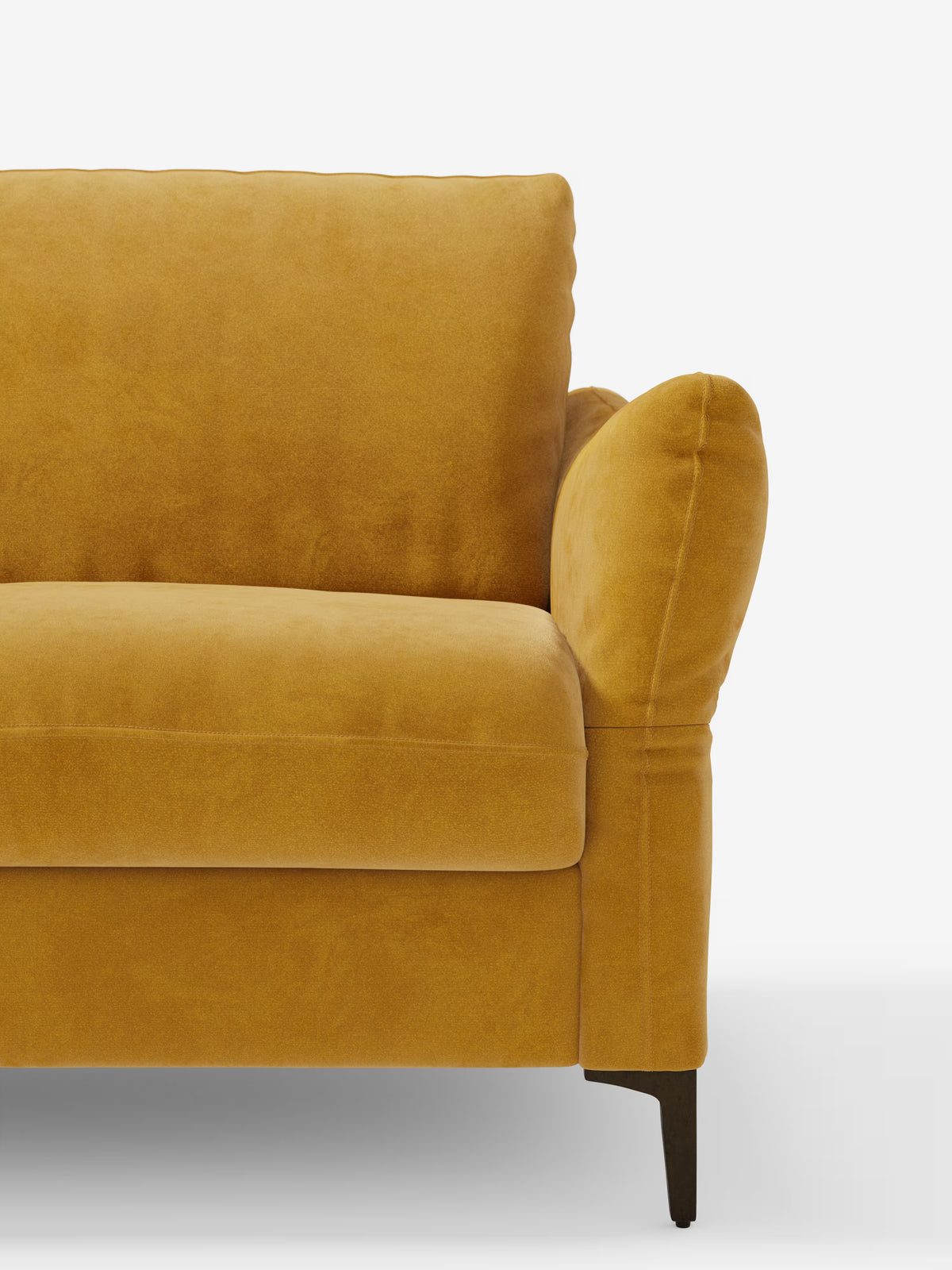 Primo piano del lato destro del divano letto “Dalia” di Divani.Store, color giallo senape, rivestito in un moderno tessuto in velluto T30 resistente alle macchie, caratterizzato da un bracciolo imbottito, uno schienale morbido e una gamba in legno scuro. Su uno sfondo bianco a tinta unita è visibile solo metà di questo divano letto dal design contemporaneo.