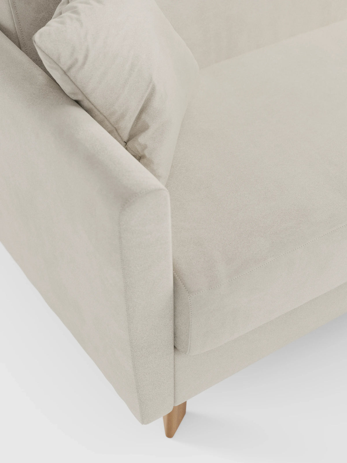 Un primo piano del divano letto Francy con poggiatesta regolabili di Divani.Store, rivestito in elegante tessuto T30 beige resistente alle macchie. Questo moderno divano a due posti è dotato di rivestimenti completamente sfoderabili, seduta, schienale e braccioli imbottiti. Un cuscino quadrato abbinato è posizionato in un angolo, mentre il divano poggia su gambe corte e angolate in legno su uno sfondo bianco.