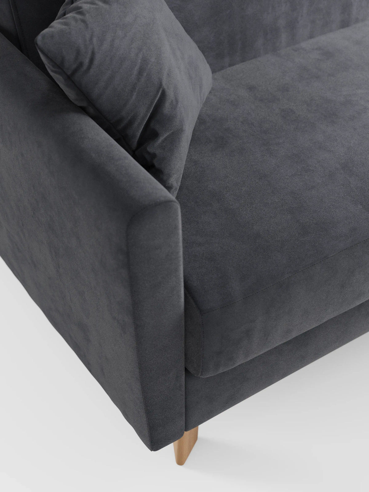 Primo piano di un divano letto Francy grigio scuro con poggiatesta regolabili di Divani.Store, caratterizzato da braccioli e cuscini di seduta rivestiti in elegante tessuto T30 antimacchia, dall’aspetto morbido e vellutato. Un cuscino coordinato è appoggiato sul divano, che poggia su gambe in legno chiaro ed è posizionato su uno sfondo bianco a tinta unita. Il divano è dotato di rivestimento sfoderabile al 100% per una facile pulizia.