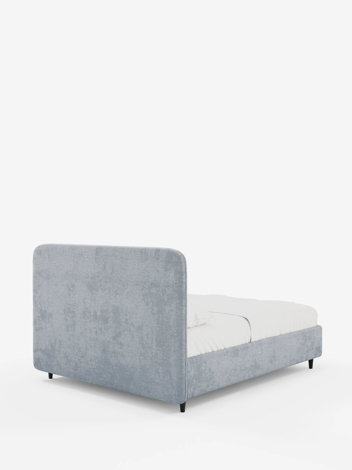 Una vista posteriore del letto KAELOS minimal imbottito in ciniglia azzurra, caratterizzato da una testiera arrotondata, biancheria da letto bianca e gambe corte, scure e affusolate, su uno sfondo bianco.
