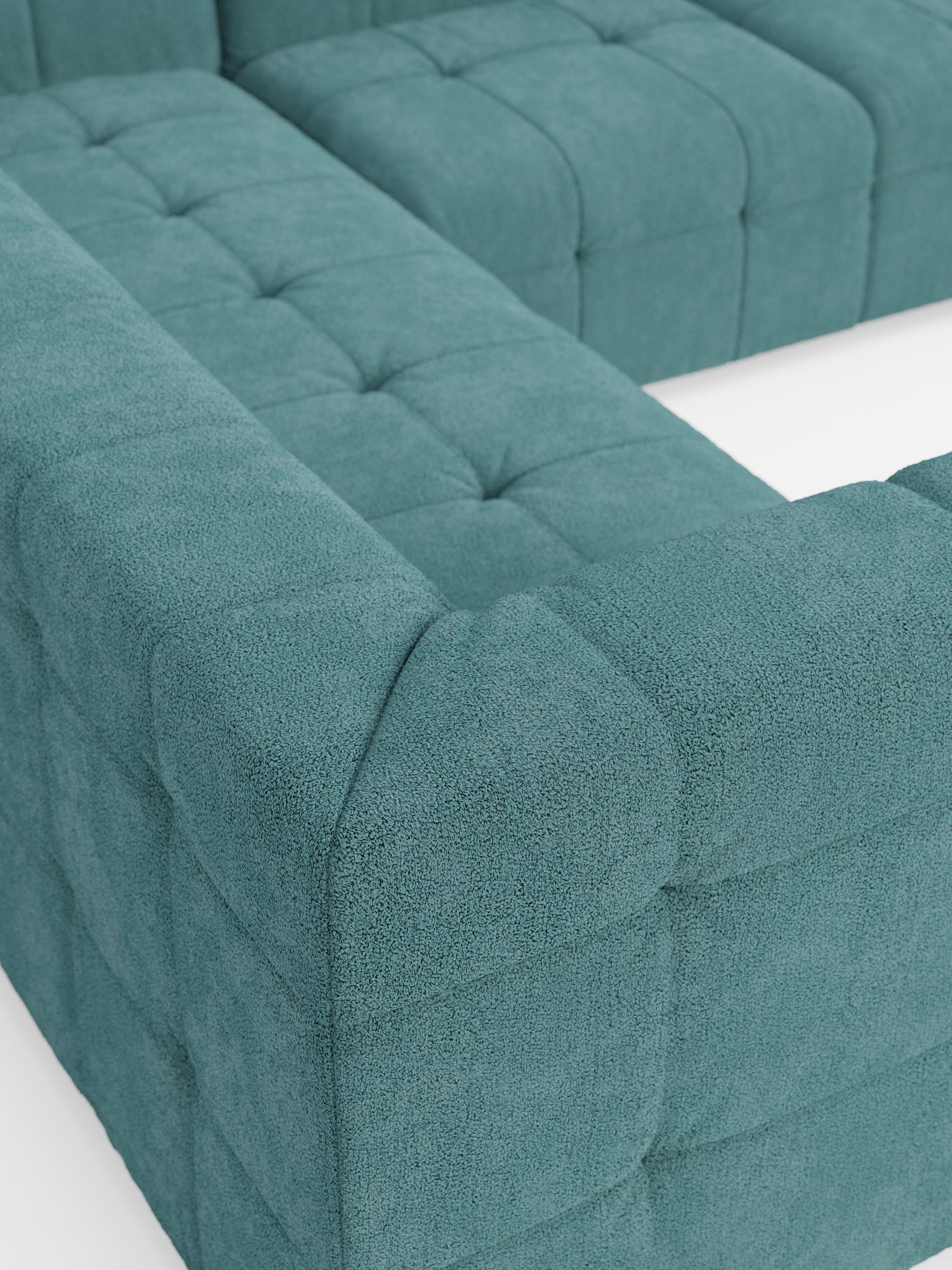 Primo piano del divano angolare componibile e modulare “Mosaic” in bouclé di Divani.Store, caratterizzato da un design trapuntato color verde acqua con tessuto T21 testurizzato e resistente alle macchie. I cuscini e i braccioli presentano motivi di cuciture quadrate, mentre il divano è disposto a forma di L su uno sfondo bianco.