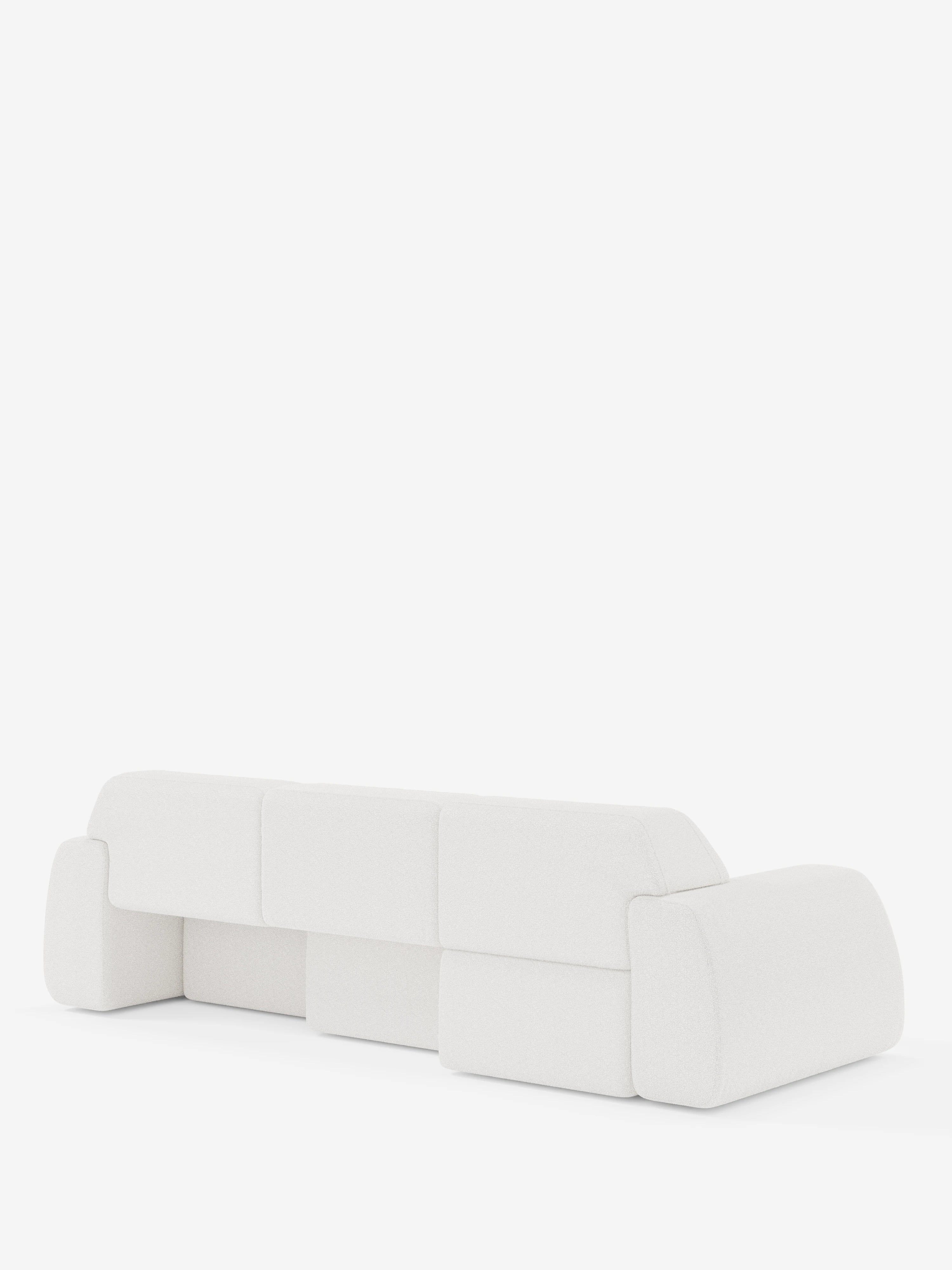 Un divano bianco in stile contemporaneo, con bordi arrotondati e schienale basso, è ripreso da dietro su uno sfondo bianco a tinta unita. Il design prevede cuscini spessi e squadrati e ampi braccioli, per un look minimalista e moderno. Il divano Orbit con 3 sedute scorrevoli e allungabili in tessuto effetto cotone smacchiabile T33 di Divani.Store è completamente sfoderabile, unendo un’estetica elegante alla praticità della manutenzione.