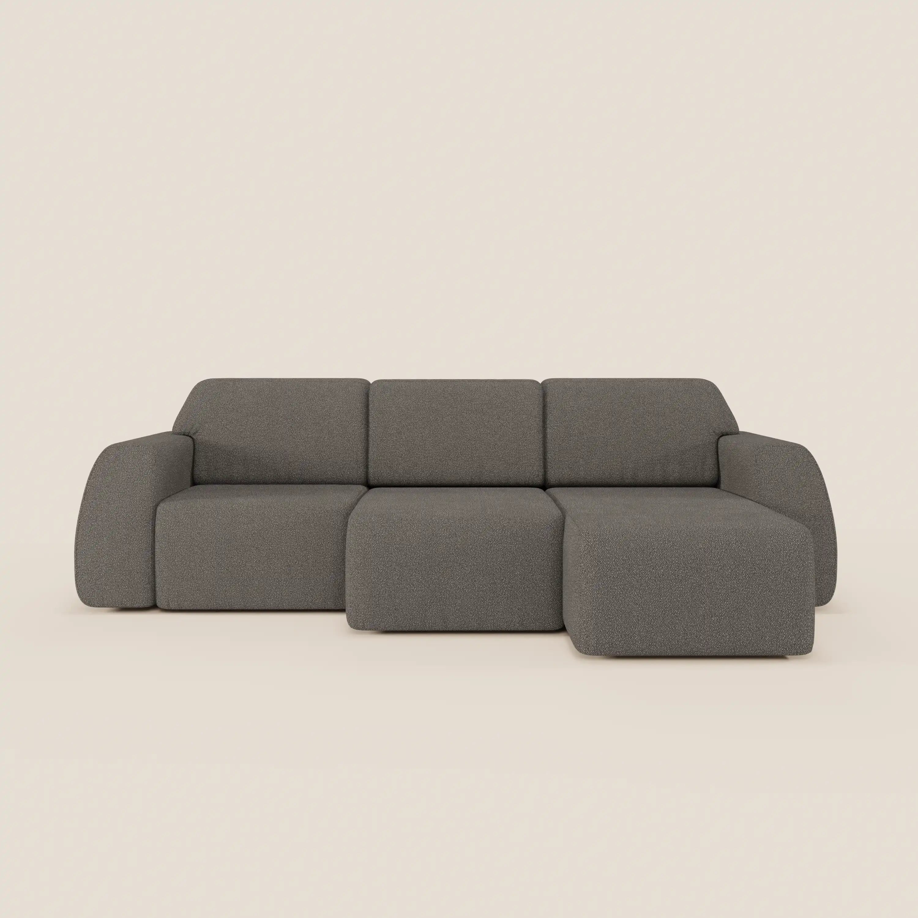 Il divano angolare Orbit di Divani.Store è caratterizzato da una penisola reversibile, tutte le sedute allungabili e tessuto smacchiabile effetto cotone T33 in grigio, con design minimalista e ampi braccioli su uno sfondo beige chiaro.