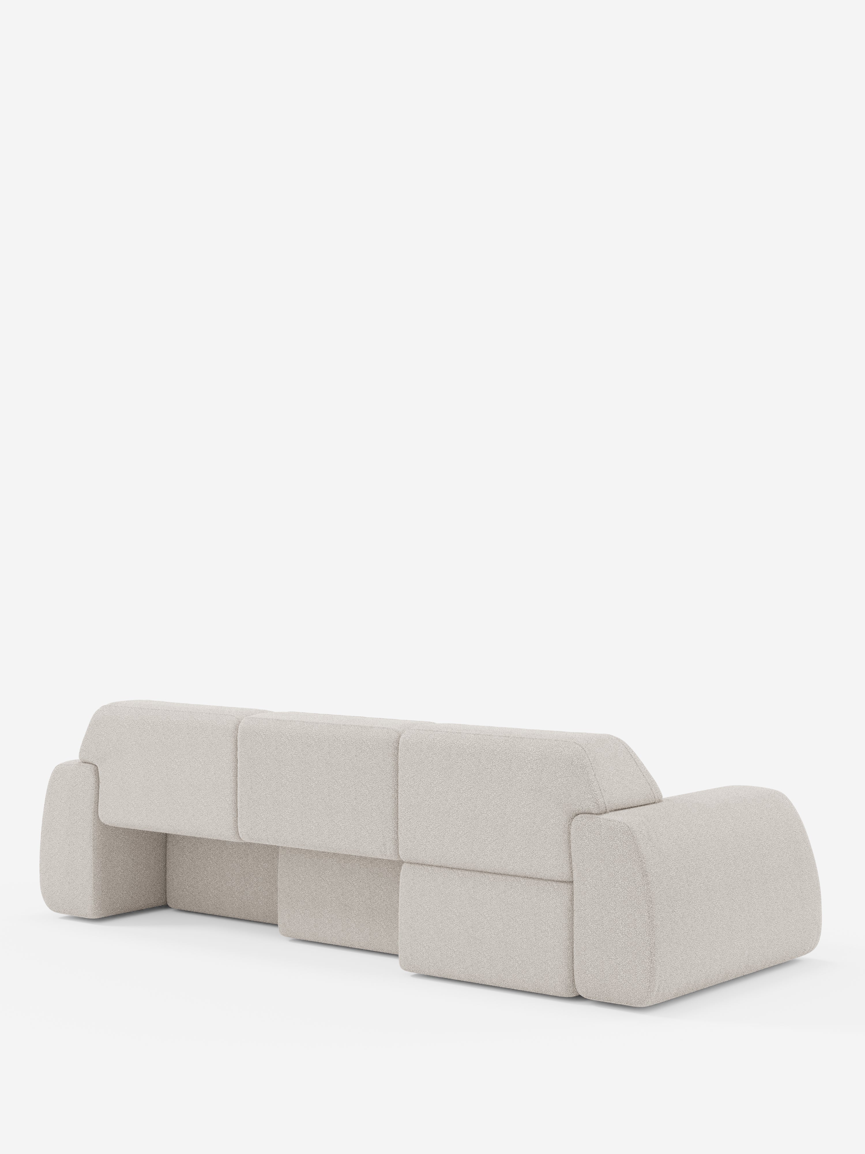 Il divano angolare contemporaneo Orbit con penisola reversibile e tutte le sedute allungabili, rivestito in tessuto smacchiabile effetto cotone T33 di Divani.Store, è raffigurato di retro, mettendo in risalto il suo tessuto beige chiaro, i morbidi bordi arrotondati e i cuscini modulari. Questo divano componibile di alta gamma è posizionato su uno sfondo bianco, senza gambe visibili né dettagli aggiuntivi.