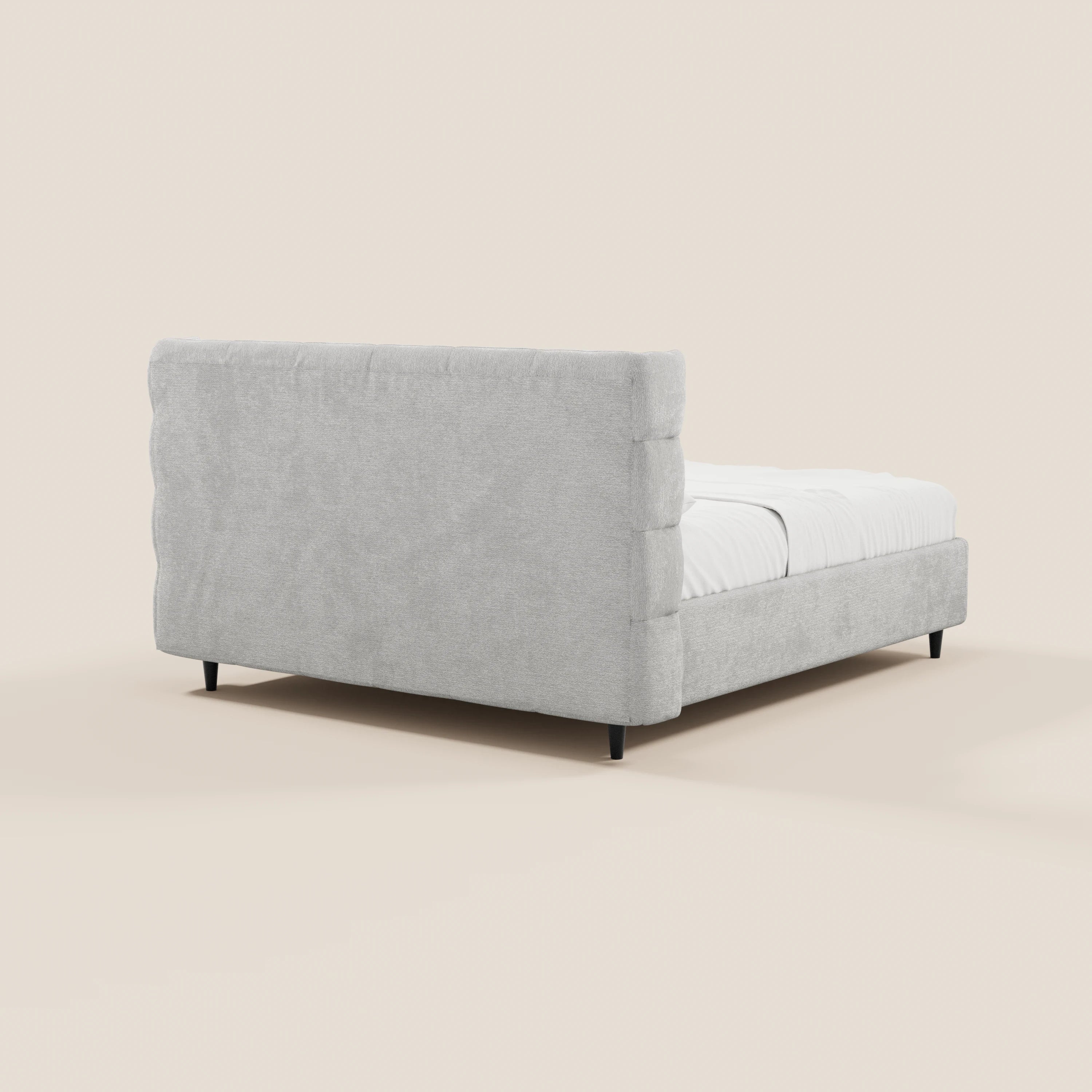 Il letto imbottito RAGNAR con contenitore e testiera capitonné avvolgente di Letti.store, presentato in tessuto grigio chiaro certificato Oeko-Tex®, con testiera altamente imbottita, pediera bassa e gambe corte nere su uno sfondo chiaro.