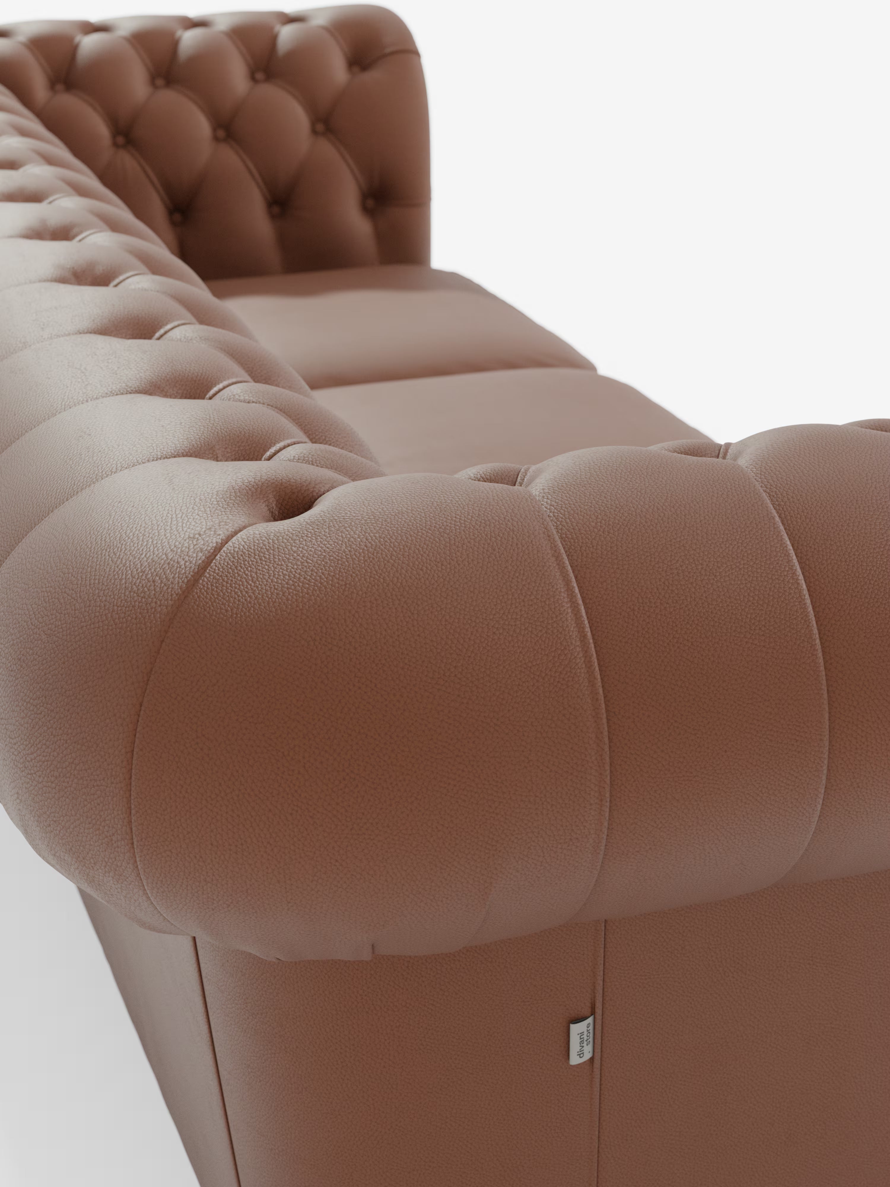 Primo piano del divano Chester 4 Posti 3 sedute in Vera Pelle – Chesterfield Capitonné Artigianale di Divani.Store, che mette in risalto il rivestimento in vera pelle marrone granulata con profonda trapuntatura a bottoni. L’immagine evidenzia lo schienale e i braccioli dalle curve eleganti, realizzati secondo la vera tradizione artigianale. Sul pannello frontale inferiore è visibile una piccola etichetta in tessuto, che spicca su uno sfondo bianco a tinta unita.