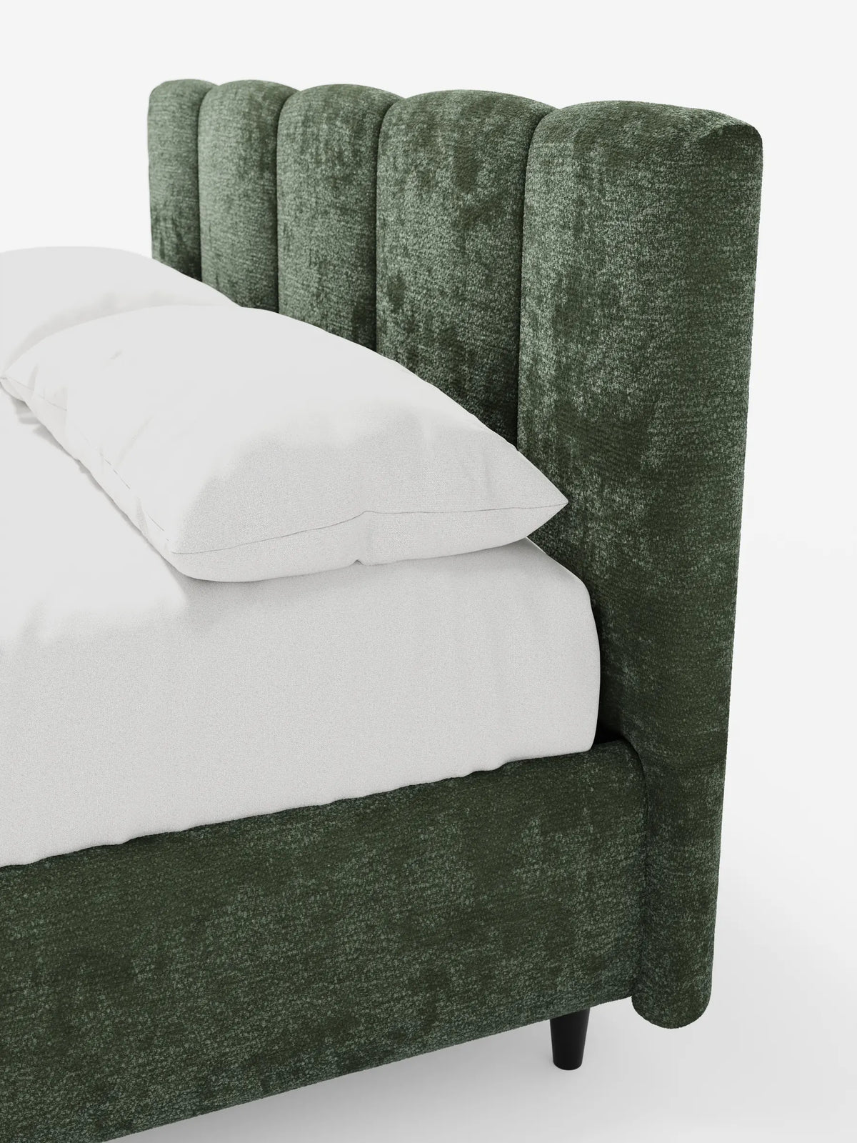 Un primo piano di un letto imbottito ARKAM con contenitore e testiera a lavorazione verticale, caratterizzato da una struttura verde bosco con finitura testurizzata, una testiera alta e imbottita con cuciture a canalini verticali, biancheria da letto bianca e gambe cilindriche sottili di colore scuro.