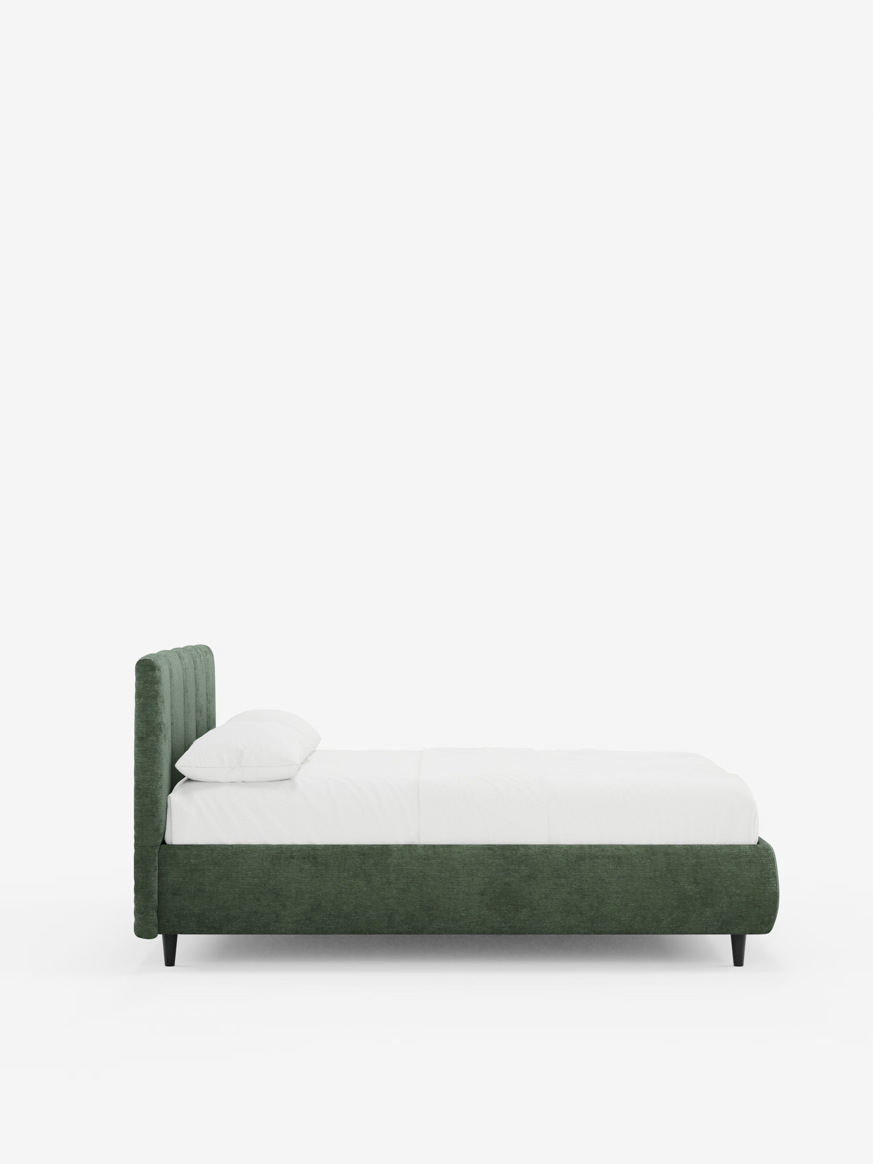 Vista laterale del letto imbottito ARKAM con contenitore e testiera a lavorazione verticale di Letti.store, caratterizzato da una struttura in tessuto verde certificato Oeko-Tex® e da una testiera con dettagli verticali, rivestito con biancheria da letto bianca e un unico cuscino bianco. Il letto poggia su corte gambe nere e presenta un design minimalista e contemporaneo in stile shabby chic su uno sfondo bianco a tinta unita.