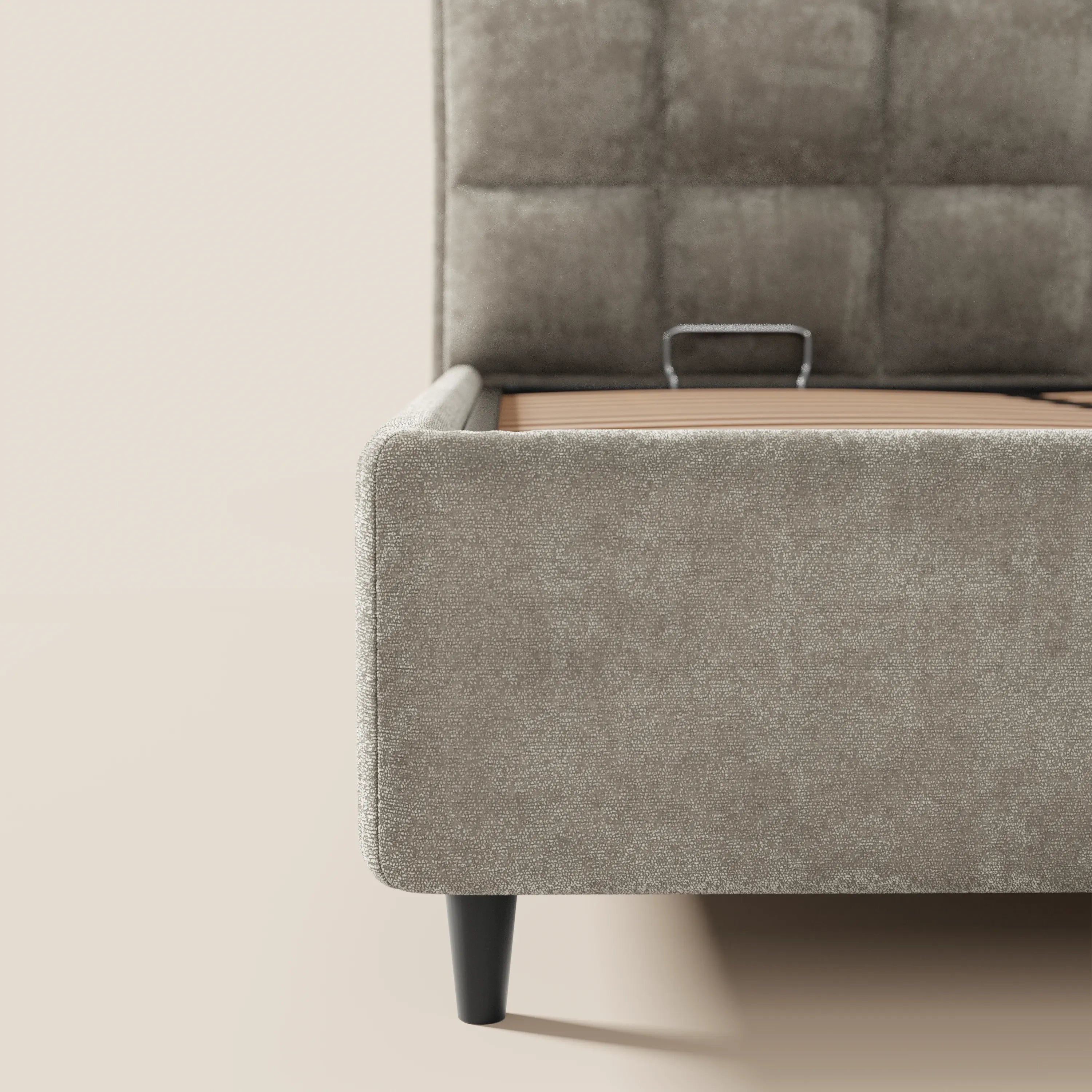 Primo piano del letto imbottito AURO di Letti.store, caratterizzato da una testiera alta capitonné in ciniglia certificata Oeko-Tex® e da un vano portaoggetti. Il suo elegante design nei toni del grigio-beige chiaro dona un tocco di stile e comfort alla tua camera da letto.