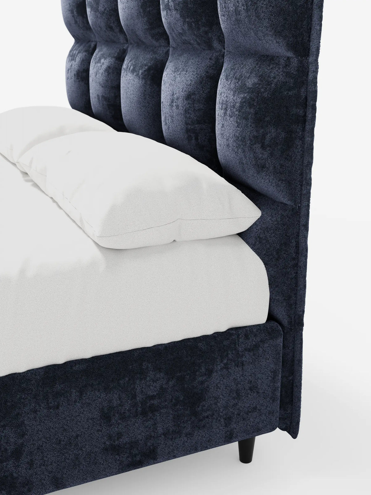 Il letto imbottito AURO con contenitore e testiera alta capitonné in ciniglia Oeko-Tex® è un letto imbottito di colore blu navy scuro con una testiera alta capitonné in morbido tessuto, rivestito con lenzuola bianche su uno sfondo bianco a tinta unita.