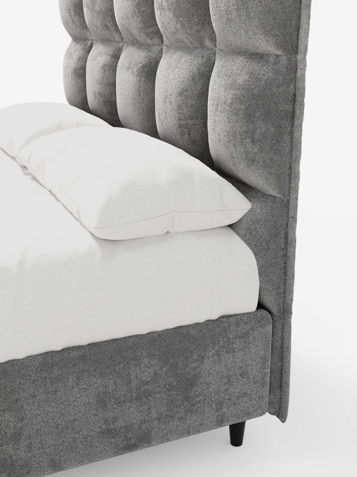 Una vista laterale ravvicinata di un letto imbottito AURO con contenitore e testiera alta capitonné in ciniglia Oeko-Tex®, realizzato in tessuto grigio testurizzato, caratterizzato da una testiera alta capitonné e da biancheria da letto bianca su uno sfondo bianco a tinta unita.