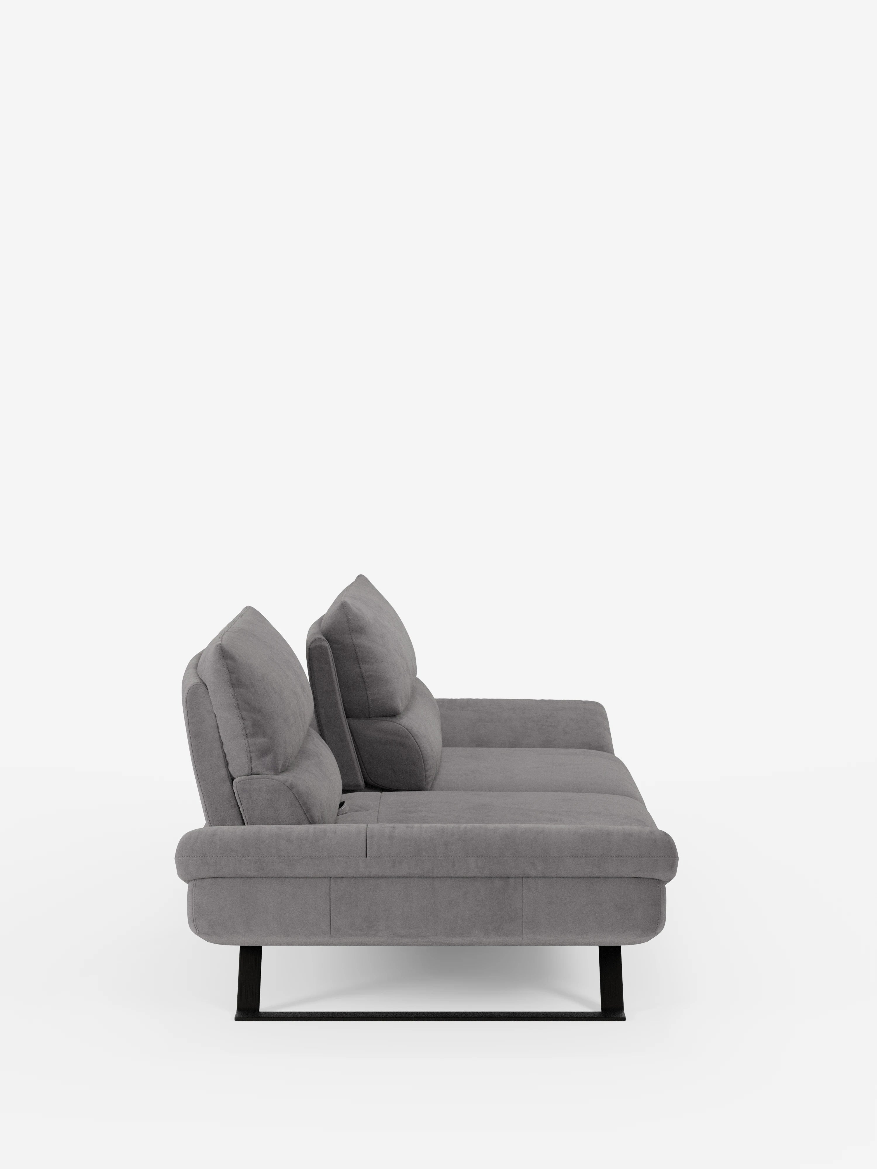 Una vista laterale mette in risalto il divano Eclipse Divano dal design moderno a 2 e 3 posti di Divani.Store, rivestito in elegante microfibra T11 grigio chiaro resistente alle macchie. Questo divano contemporaneo presenta due cuscini di seduta, due cuscini dello schienale con schienali leggermente reclinabili e regolabili (schienali traslanti), braccioli bassi e piedini alti in metallo nero, il tutto su uno sfondo bianco a tinta unita.