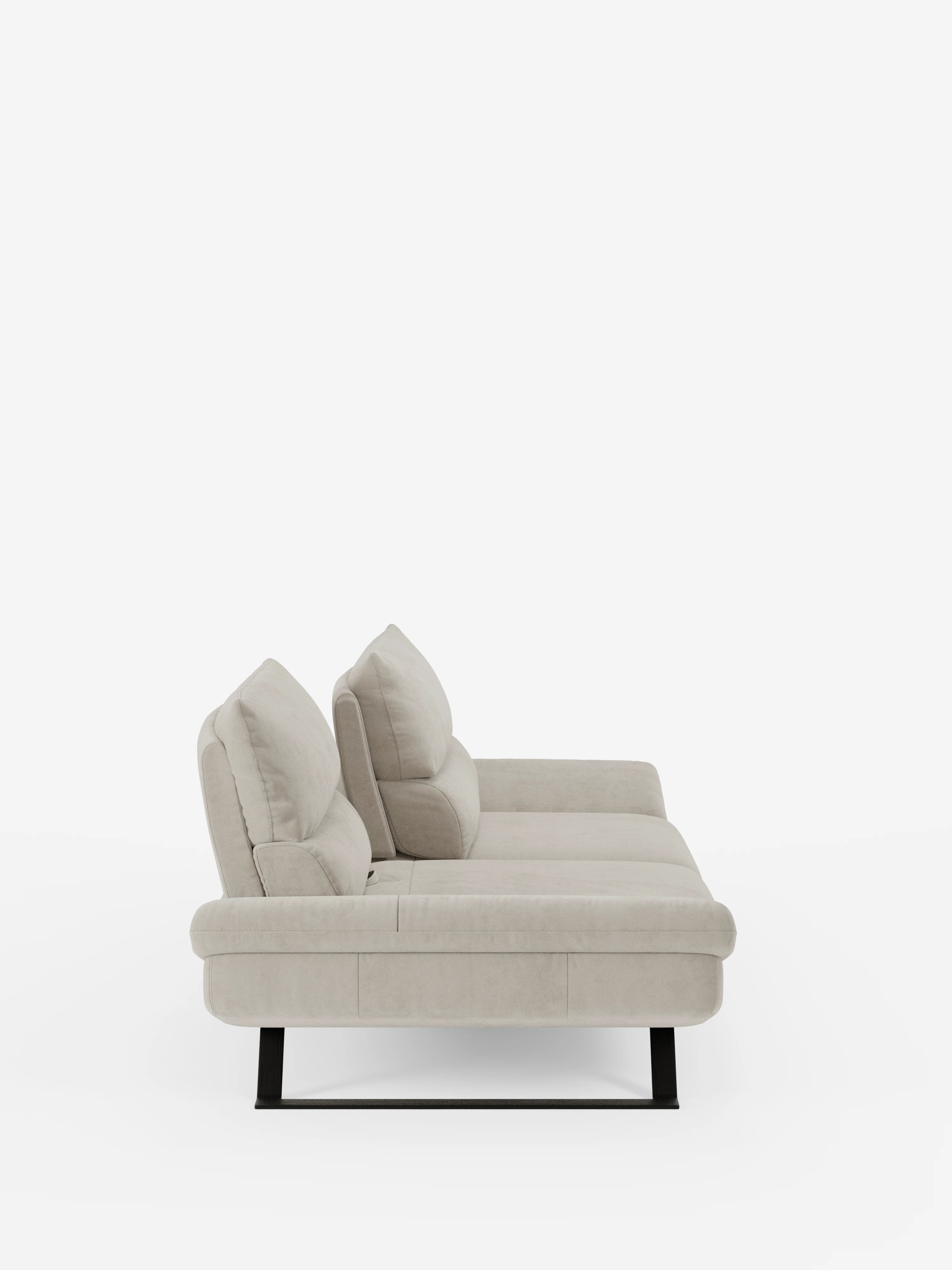 Il divano Eclipse dal design moderno di Divani.Store, rivestito in elegante microfibra T11 resistente alle macchie e dotato di due cuscini dello schienale, è qui raffigurato in una vista laterale. Il divano presenta un profilo ribassato e un rivestimento morbido con piedini alti in metallo. Uno sfondo bianco a tinta unita mette in risalto lo stile minimalista di questo divano a 2 o 3 posti con schienali regolabili (schienali traslanti).