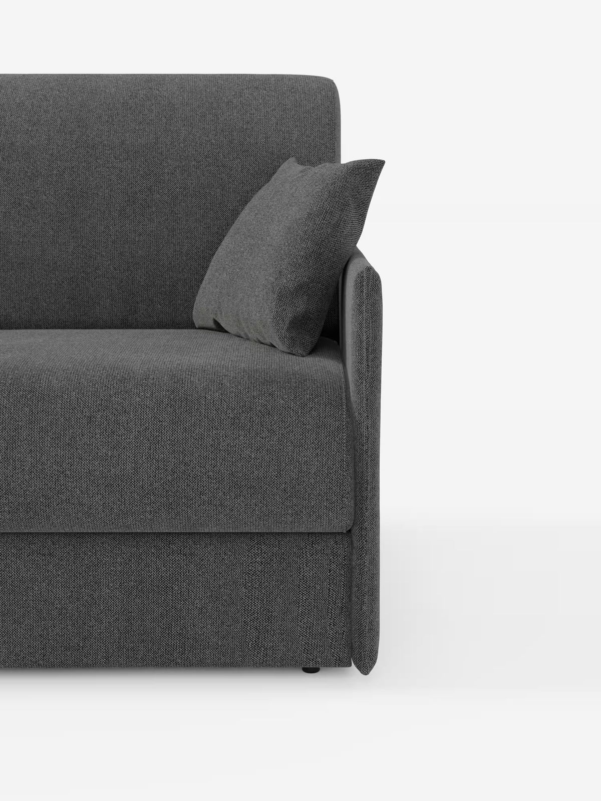 Primo piano del divano letto matrimoniale sfoderabile Evans di Divani.Store in grigio scuro, caratterizzato da un design compatto con bracciolo destro, un set di cuscini coordinati disposti ad angolo e parte della seduta e dello schienale visibili su sfondo bianco. Rivestito in tessuto T23 antimacchia, questo divano letto moderno e minimalista include un pratico vano porta guanciali, che lo rende un divano salvaspazio ideale per qualsiasi casa contemporanea.