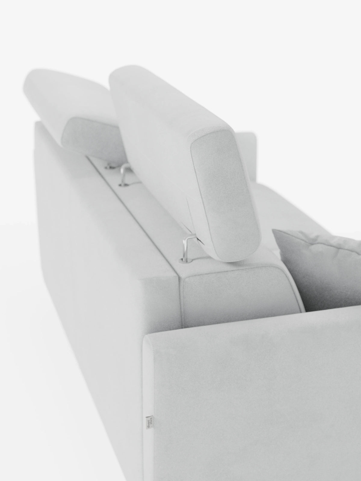 Il divano letto a due posti Francy di Divani.Store, in una versione contemporanea color grigio chiaro, è raffigurato di retro, con due poggiatesta rettangolari regolabili dotati di supporti in metallo e un unico cuscino visibile sulla destra. Lo sfondo bianco a tinta unita mette in risalto le sue linee pulite e il rivestimento in tessuto T30, morbido ed elegante, resistente alle macchie e rimovibile al 100%.