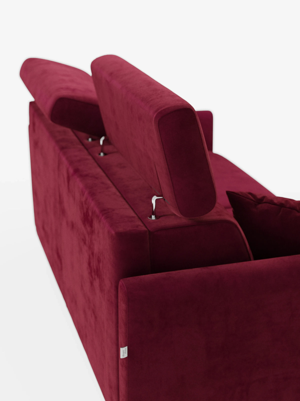 Un lussuoso divano letto Francy di colore rosso intenso con poggiatesta regolabili di Divani.Store, caratterizzato da due poggiatesta regolabili inclinati verso l’alto. L'elegante tessuto T30, resistente alle macchie, è vellutato, dalla consistenza morbida e dotato di fodere completamente sfoderabili. L'immagine è ripresa da dietro, mettendo in risalto il meccanismo dei poggiatesta e parte di un cuscino su uno sfondo bianco a tinta unita.