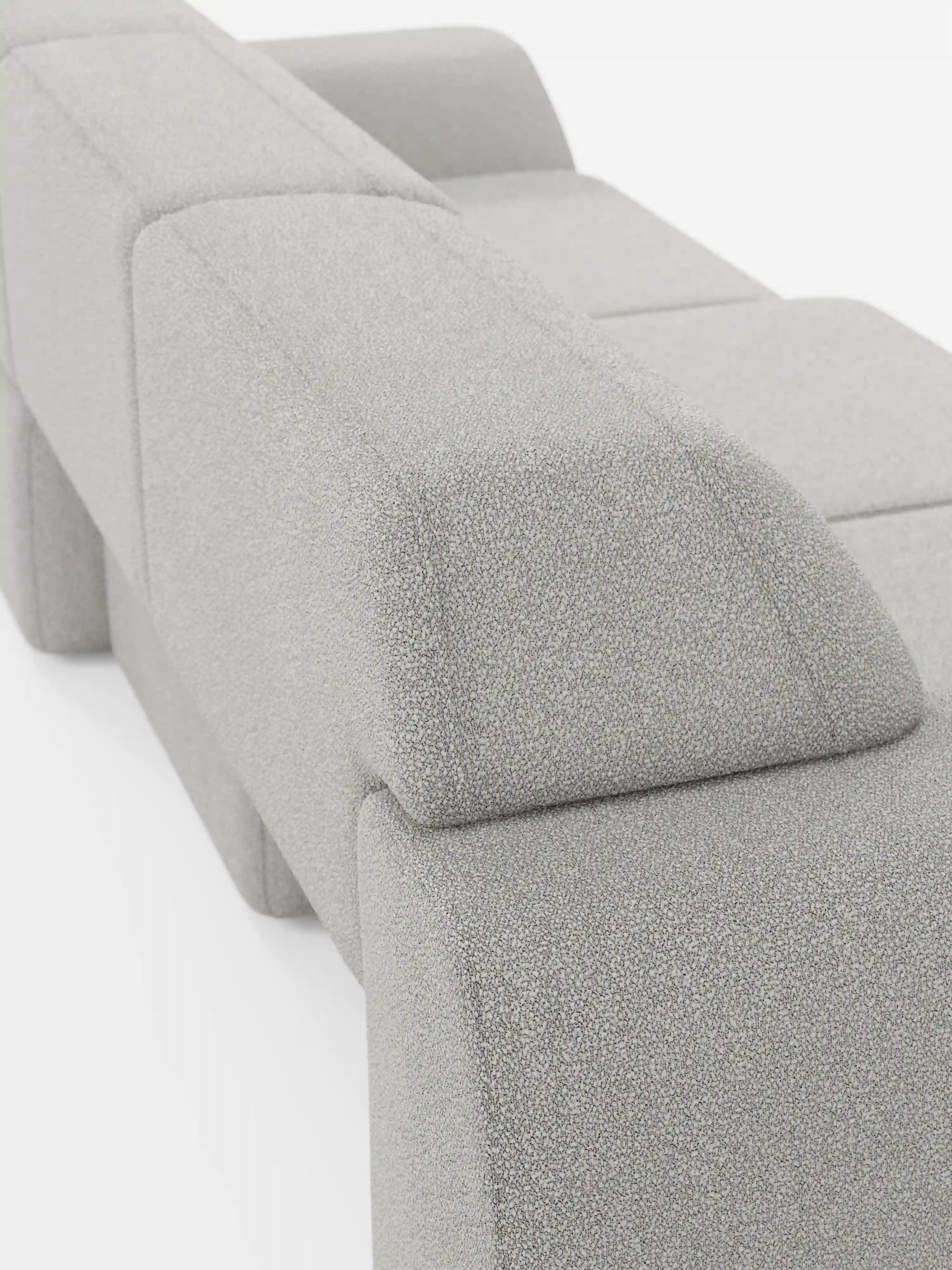 Un primo piano del divano Orbit con 3 sedute scorrevoli e allungabili in tessuto effetto cotone smacchiabile T33 di Divani.Il modello Store, che mette in risalto il suo design modulare moderno in grigio chiaro con forme geometriche squadrate e tessuto testurizzato effetto cotone antimacchia; i rivestimenti completamente sfoderabili sono ripresi di profilo sul retro su uno sfondo bianco.