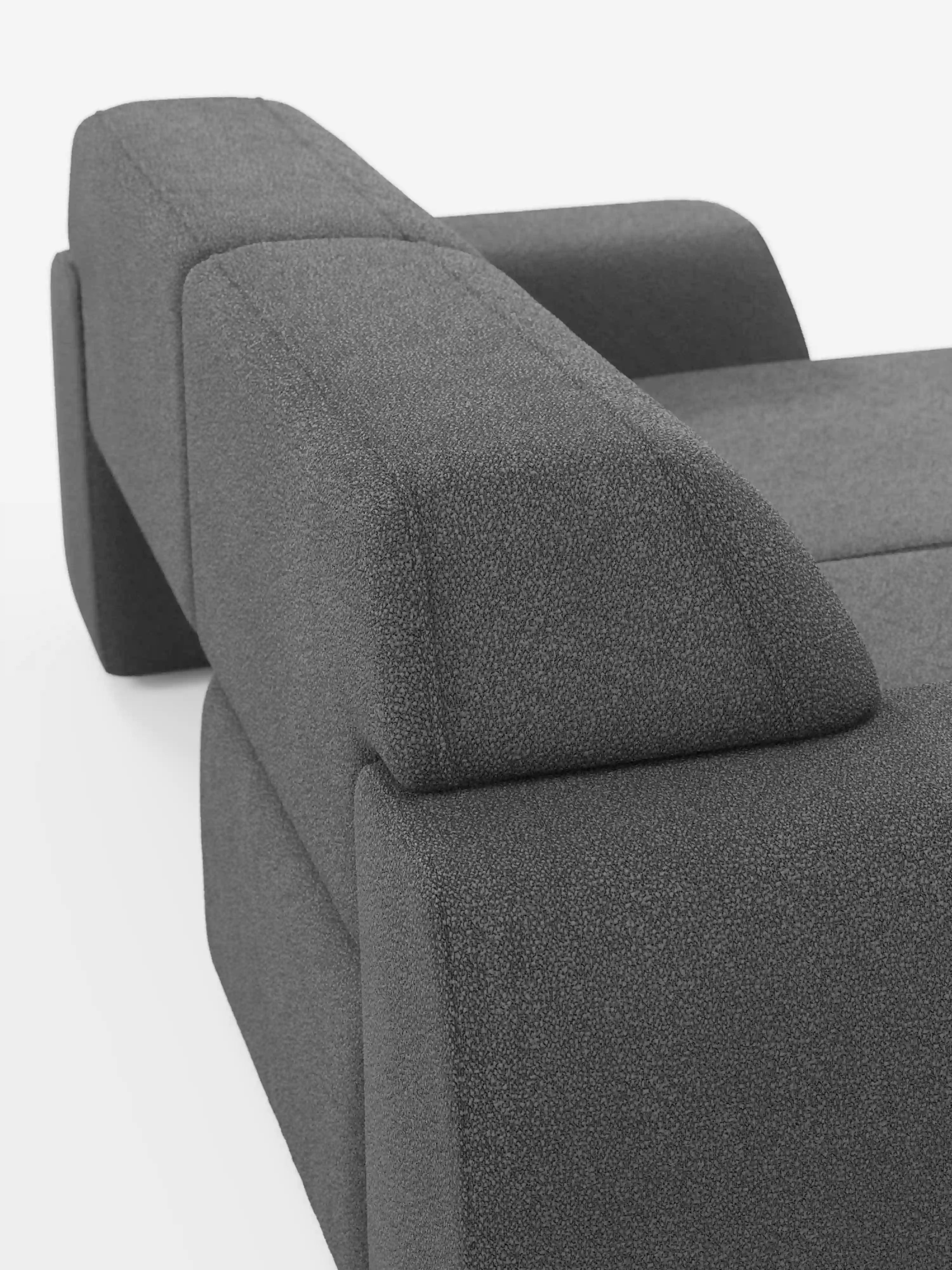 Primo piano del divano Orbit a 2 e 3 posti con sedute scorrevoli di Divani.Store, interamente rivestito in tessuto T33 smacchiabile effetto cotone. L’immagine mette in risalto il suo design geometrico moderno, caratterizzato da linee rette, braccioli e schienale spessi, il tutto in risalto su uno sfondo bianco. Il rivestimento grigio scuro e testurizzato del divano ne sottolinea l’eleganza contemporanea e la facilità di manutenzione.