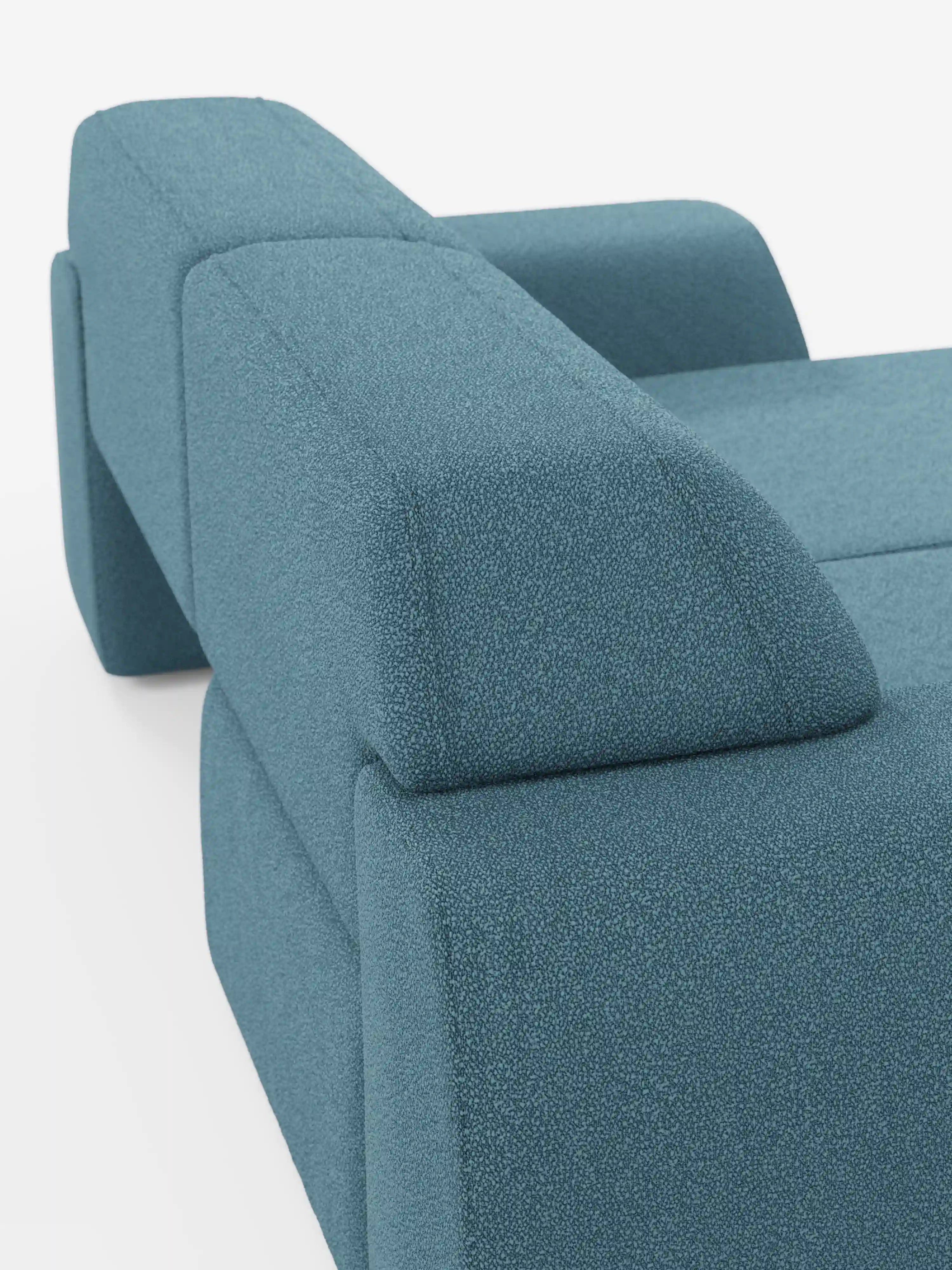 Primo piano del divano a 3 posti Orbit di Divani.Store, rivestito in tessuto smacchiabile effetto cotone T33. L'immagine mette in risalto i braccioli e lo schienale angolari, attirando l'attenzione sul design geometrico morbido e sulla trama liscia e fitta del tessuto facile da pulire, che incarna alla perfezione uno stile moderno e contemporaneo. Lo sfondo è bianco a tinta unita.