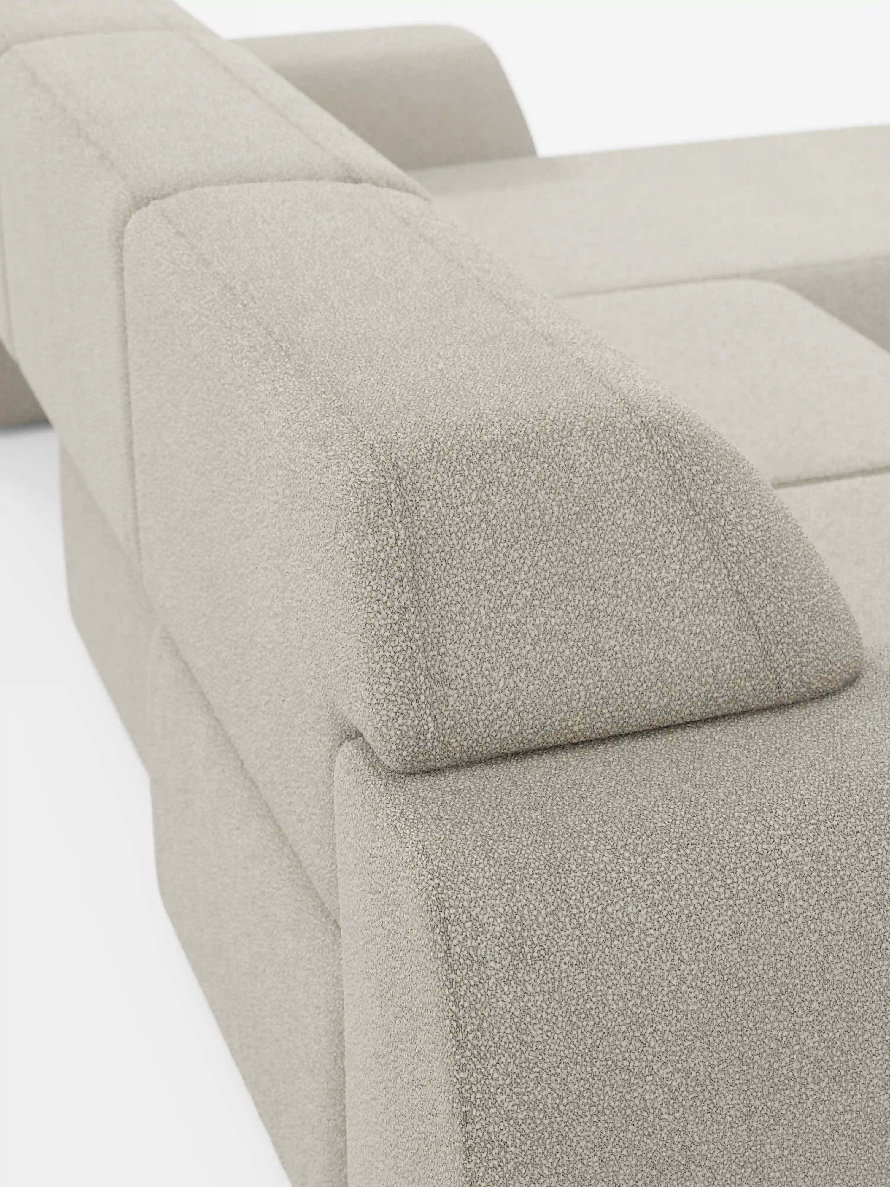 Primo piano del divano angolare Orbit con penisola reversibile e tutte le sedute allungabili di Divani.Store, rivestito in tessuto T33 beige effetto cotone, testurizzato e resistente alle macchie. L’immagine mette in risalto i braccioli geometrici del divano e la sua silhouette audace e minimalista su uno sfondo bianco a tinta unita, incarnando alla perfezione lo stile di un divano di alta gamma.