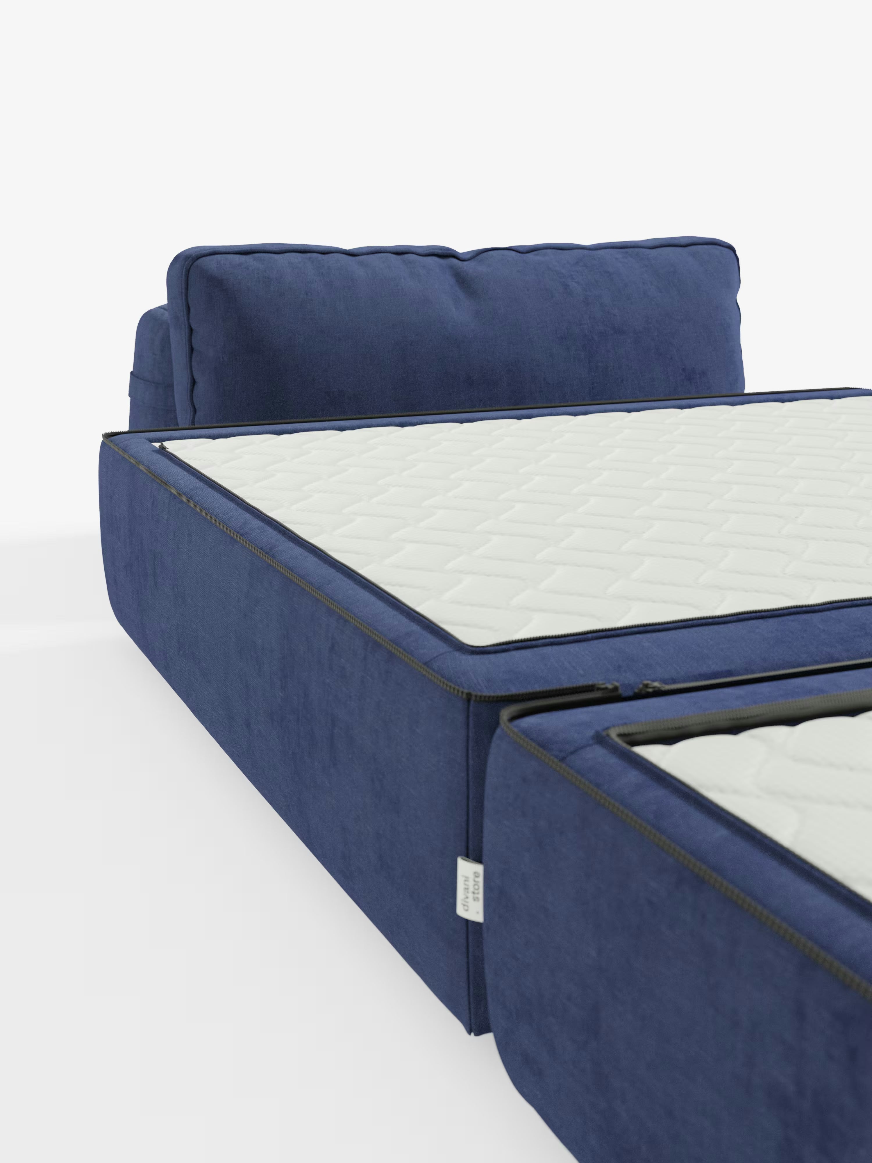 Una “Rift poltrona letto” blu di Divani.Store, caratterizzata da una struttura imbottita con una testiera morbida e imbottita e da un materasso bianco trapuntato alto 24 cm in memory foam. Il lato del letto presenta cerniere a vista e uno schienale mobile, realizzato in tessuto T31 facile da pulire. Scattata da un'angolazione bassa, l'immagine mette in risalto il lato del letto e una parte della pediera, con un altro materasso visibile nelle vicinanze.