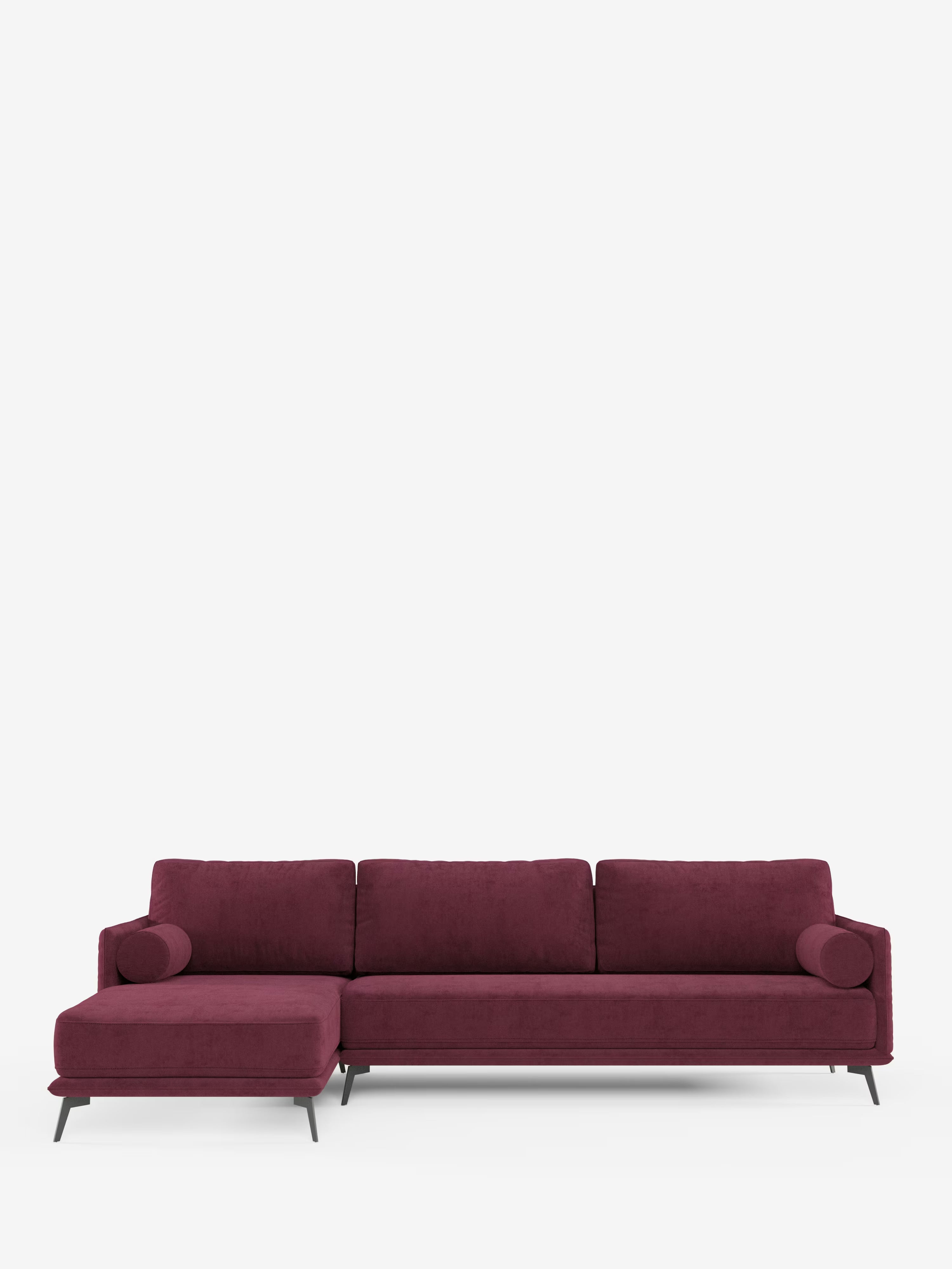 Basalto, divano moderno angolare con penisola di Divani.Store, realizzato in tessuto antimacchia T31 deep burgundy e dotato di tre cuscini di seduta, chaise longue sulla sinistra, due cuscini cilindrici coordinati e sottili gambe in metallo nero. Questo divano Made in Italy presenta una base in metallo e cuscini imbottiti in piuma, ed è posizionato su uno sfondo bianco semplice; il rivestimento sfoderabile garantisce una facile manutenzione.